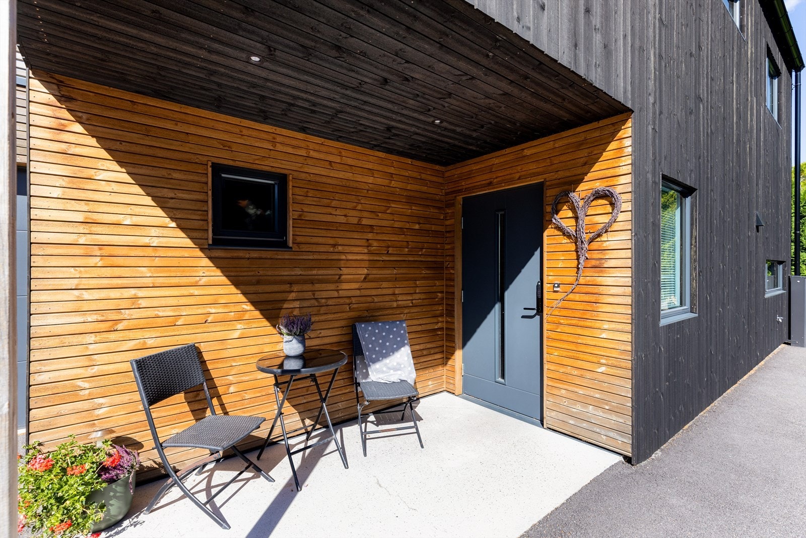 Inngangspartiet er overbygget og har fin plass til kafesett. Galleribilde