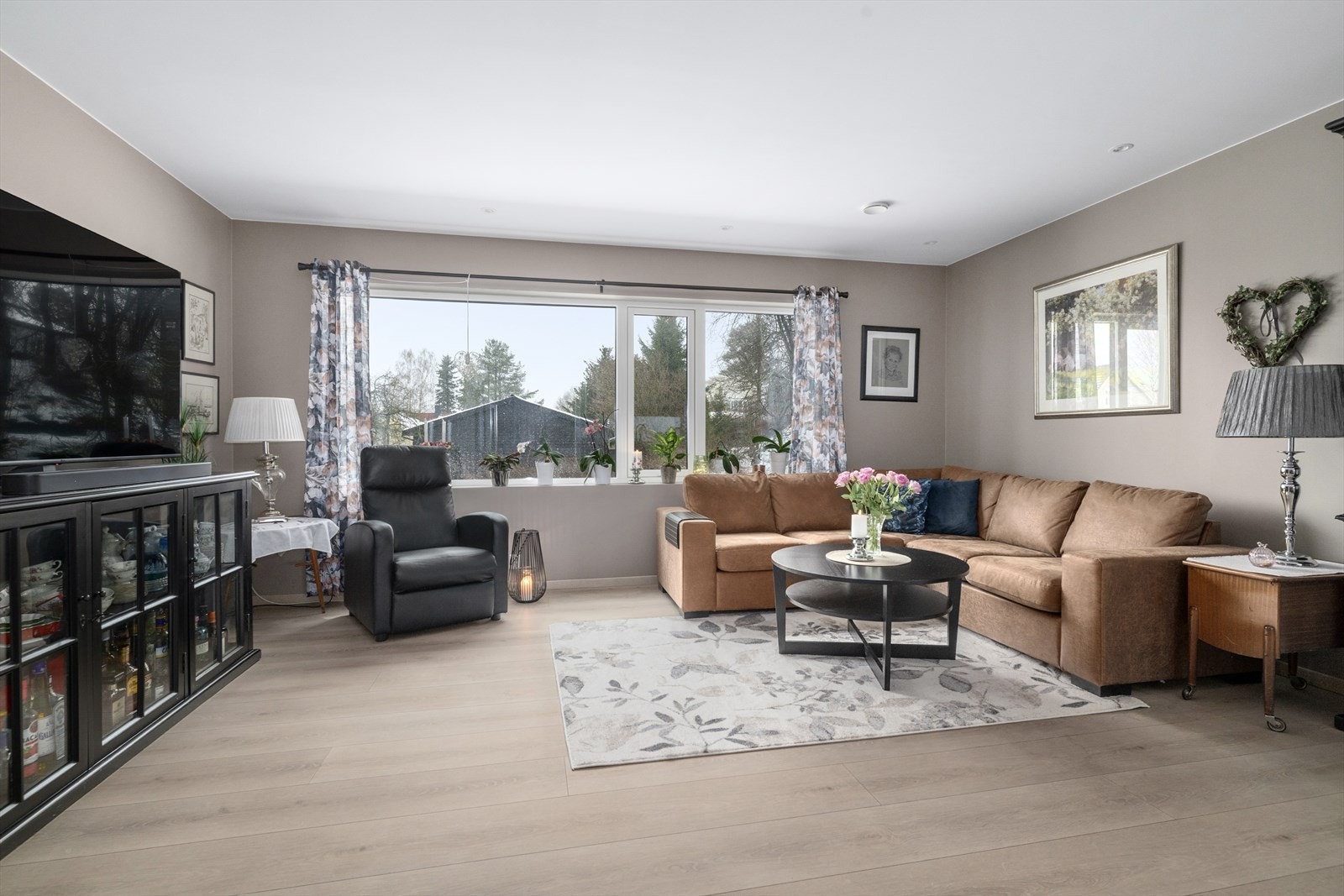 Stuen er malt opp i en lun og behagelig fargetone med slette vegger, malt himling med spotter og laminat på gulv. Galleribilde