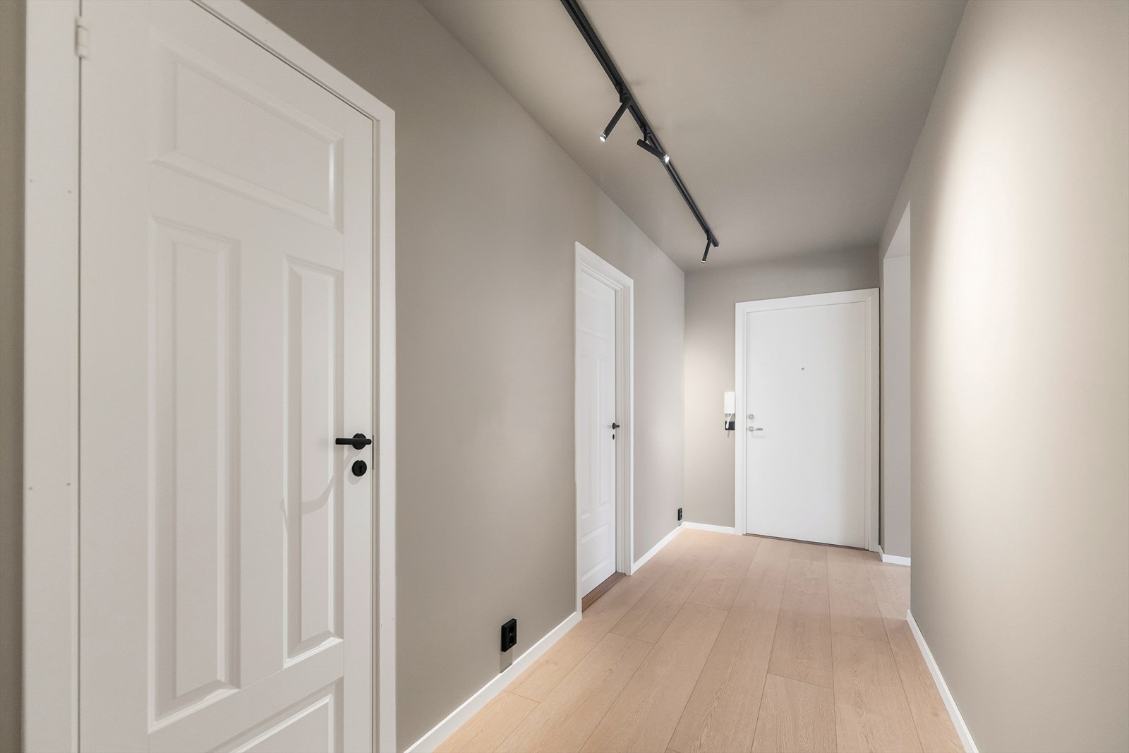 Lys og romslig gang med moderne belysning og stilrene hvite dører. Perfekt for et innbydende førsteinntrykk i hjemmet. Galleribilde
