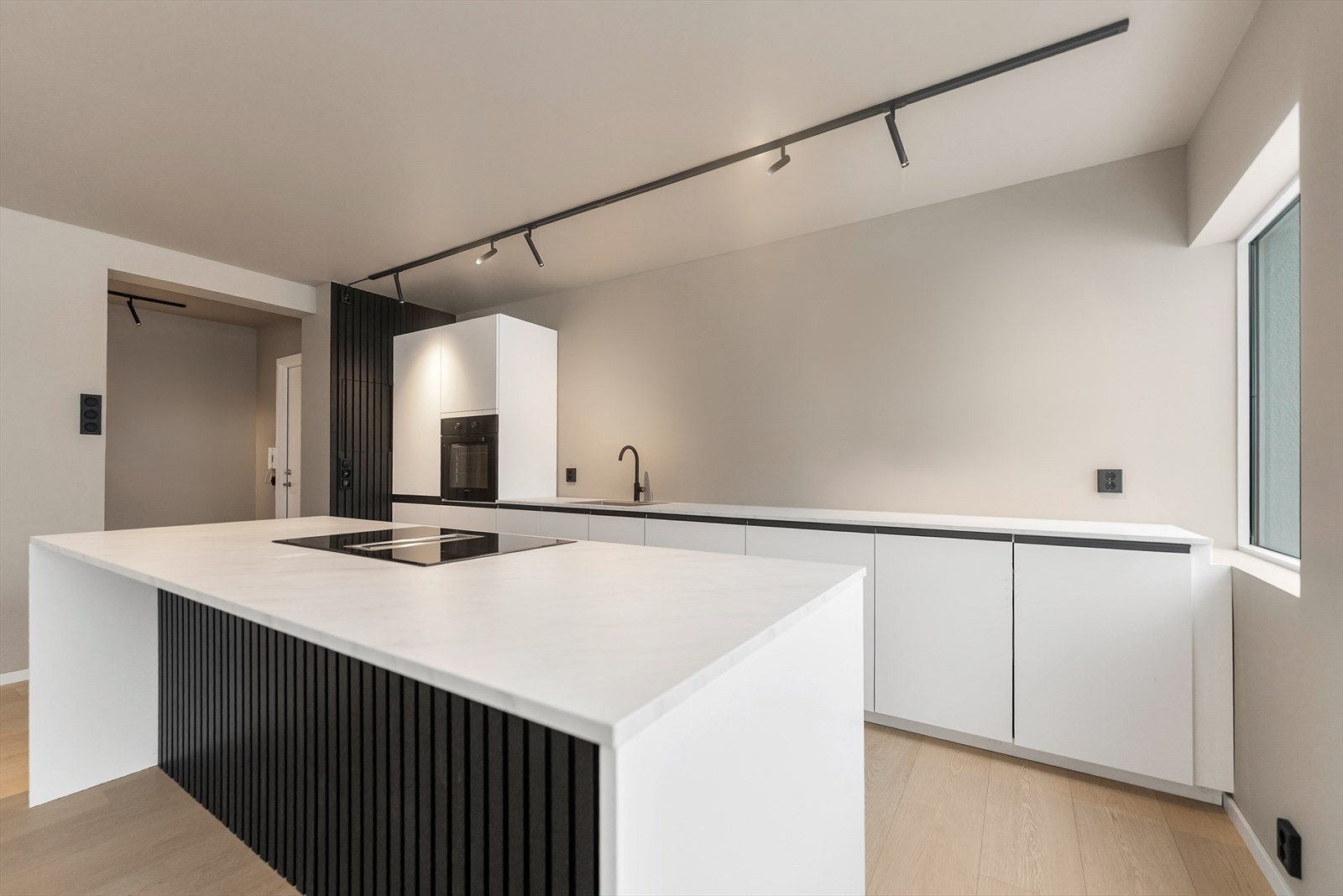 Moderne kjøkken med stilrent design og funksjonelle løsninger, ideelt for både hverdagsmatlaging og sosiale sammenkomster. Galleribilde