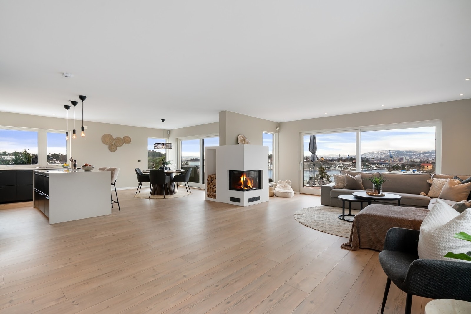 Stuen og kjøkkenet er boligens hjerte - et luftig og stilfullt rom med store vindusflater og vidstrakt utsikt mot fjorden. Galleribilde