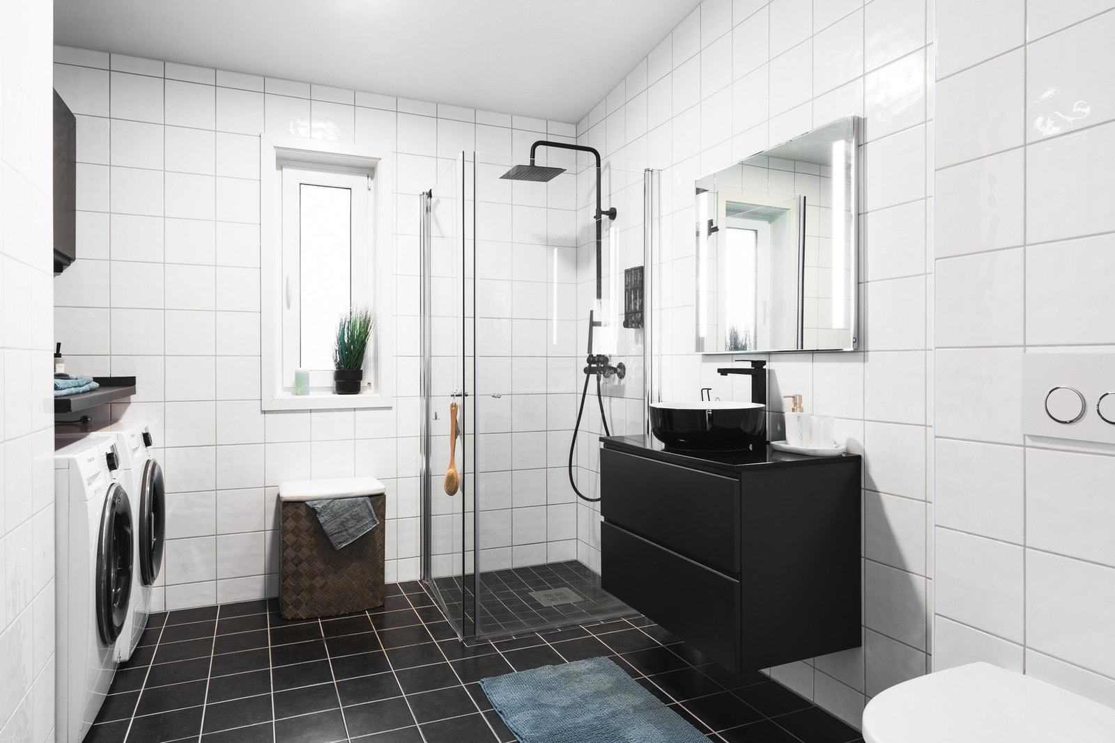 Romslig, helfliset bad på 7.4 kvm med dusj, vegghengt toalett, opplegg for vaskemaskin og baderomsinnredning. Galleribilde