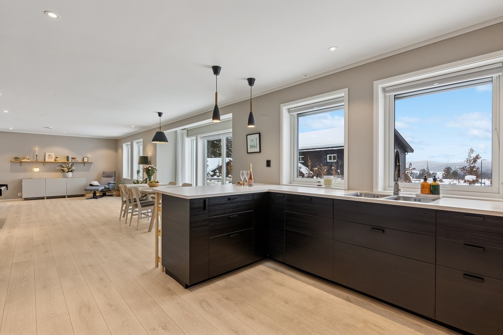 Kjøkkenet har en moderne innredning med glatte fronter og laminat benkeplate Galleribilde