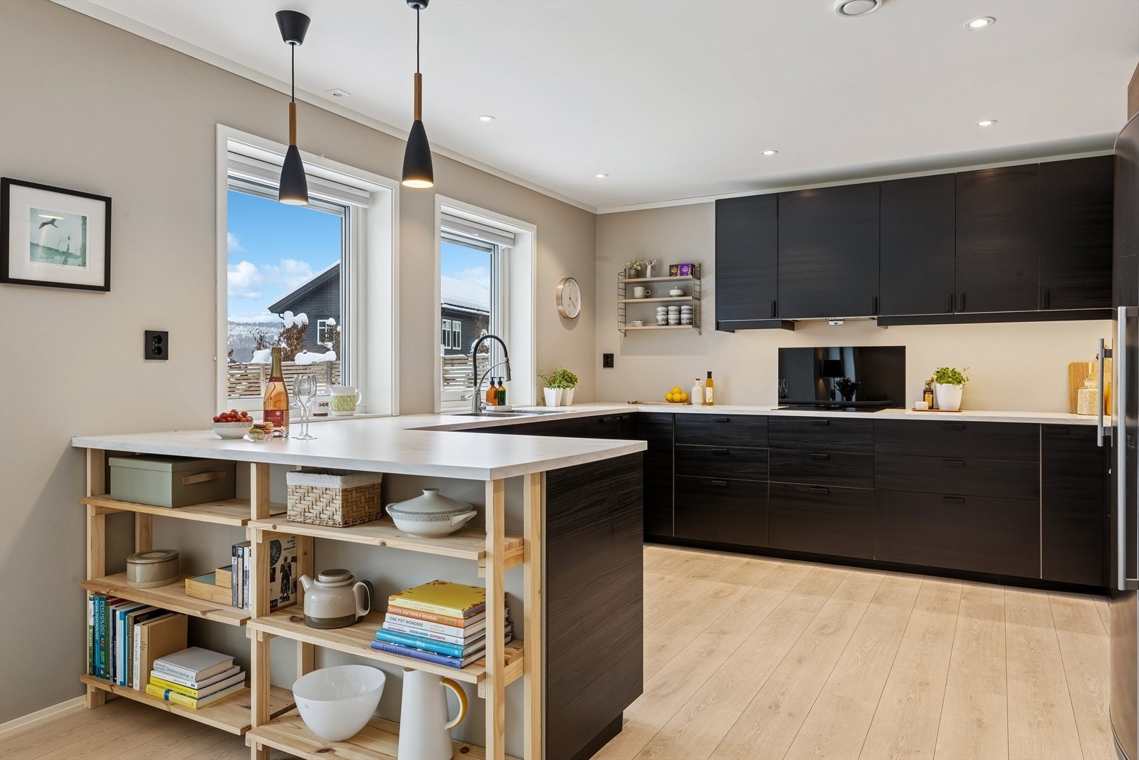 Den åpne hylleløsningen på øya gir ekstra oppbevaring og et personlig preg (kan enkelt fjernes om man heller vil ha plass til barkrakker) Galleribilde