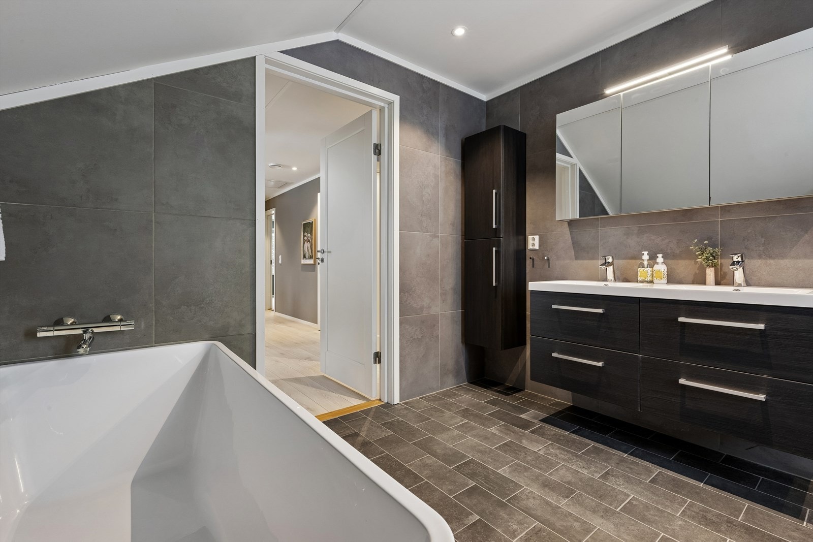 Det romslige badet i loftsetasjen er utstyrt med både badekar og dusj Galleribilde