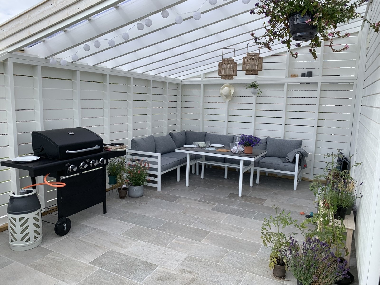 Den overbygde terrassen fungerer som en lun og innbydende hagestue, et perfekt tilfluktssted gjennom store deler av året Galleribilde