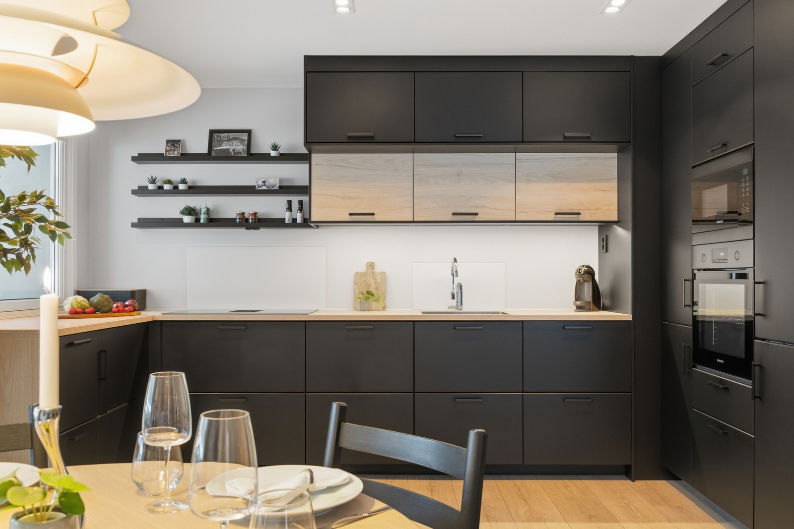 Stilig kjøkken med integrerte hvitevarer. Skap helt opp til taket sørger for ekstra lagringsplass til alt man ikke bruker like ofte. Galleribilde