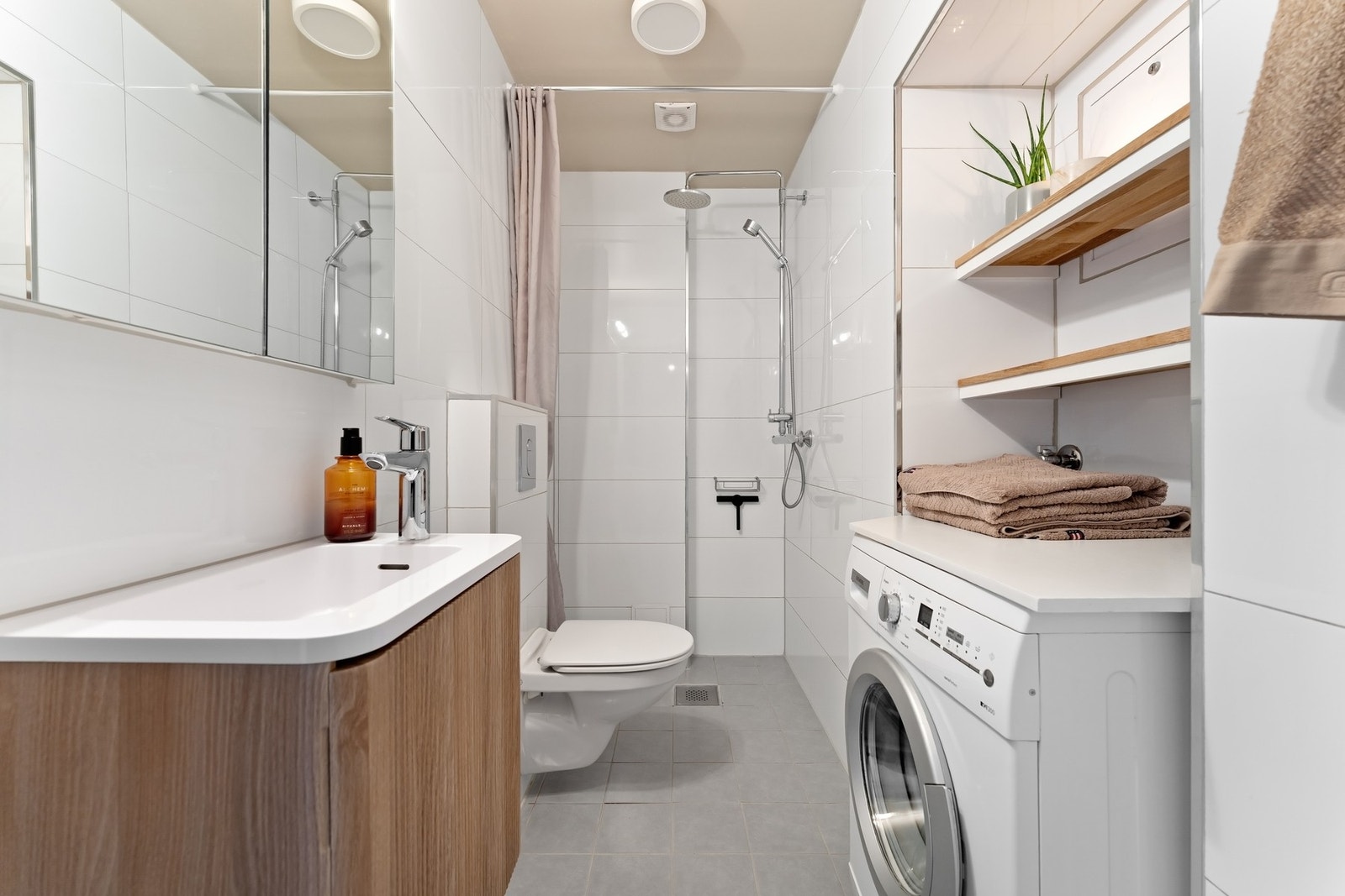 Dusjhjørnet er utstyrt med både regndusj og hånddusj, samt forheng. Det er opplegg for vaskemaskin. Galleribilde