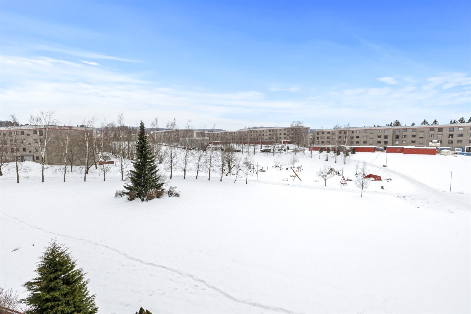Fra leiligheten er det utsikt over store, grønne fellesarealer med lekeplass. Galleribilde