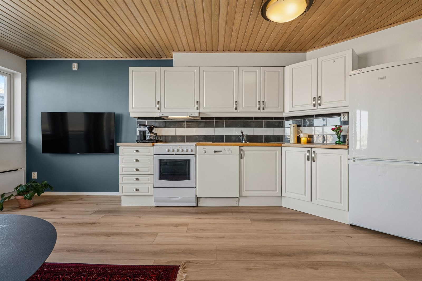 Kjøkkenet har en innredning med profilerte fronter med plass til frittstående hvitevarer. Galleribilde