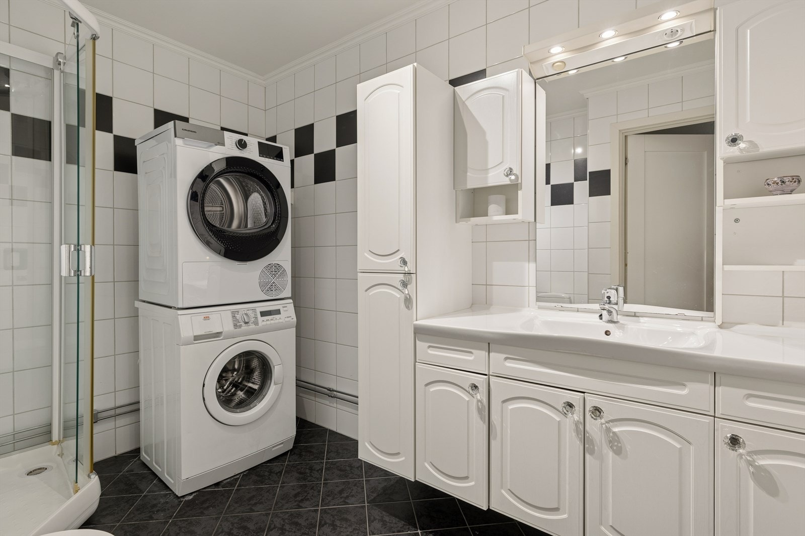 Badet er flislagt og har gulvvarme. Innredning med nedfelt servant, toalett, dusjkabinett og opplegg for vaskemaskin. Galleribilde