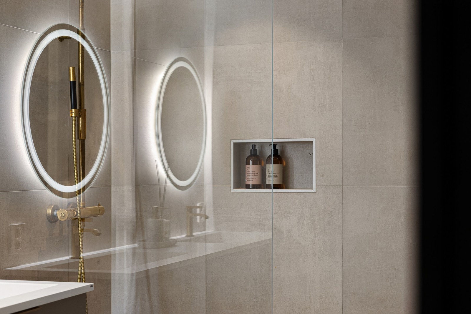 Flotte og praktiske detaljer med integrerte hyller i dusj og over badekaret. Galleribilde