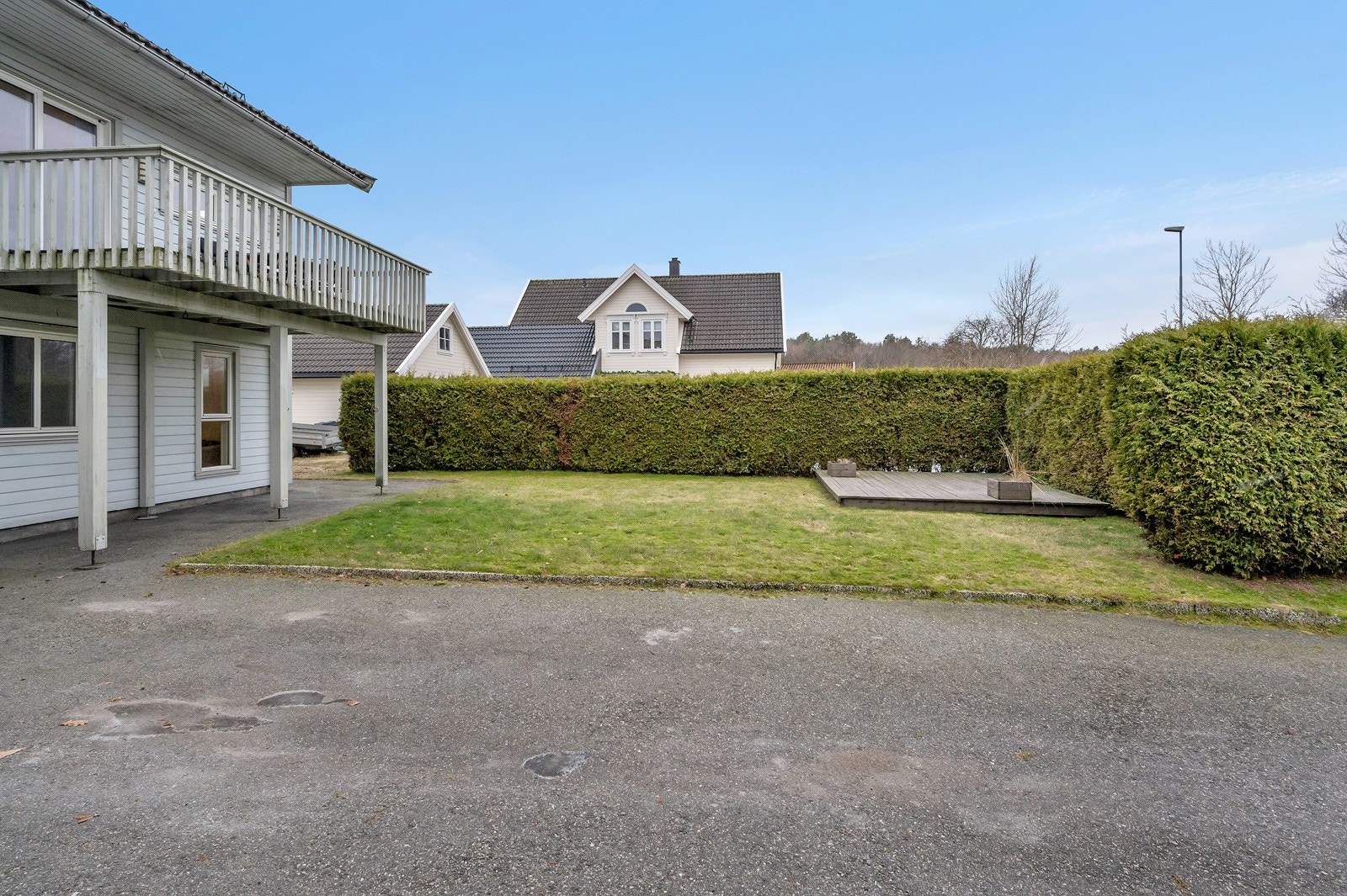 Boligen har et romslig uteområde med både parkeringsmuligheter og store plenområder Galleribilde