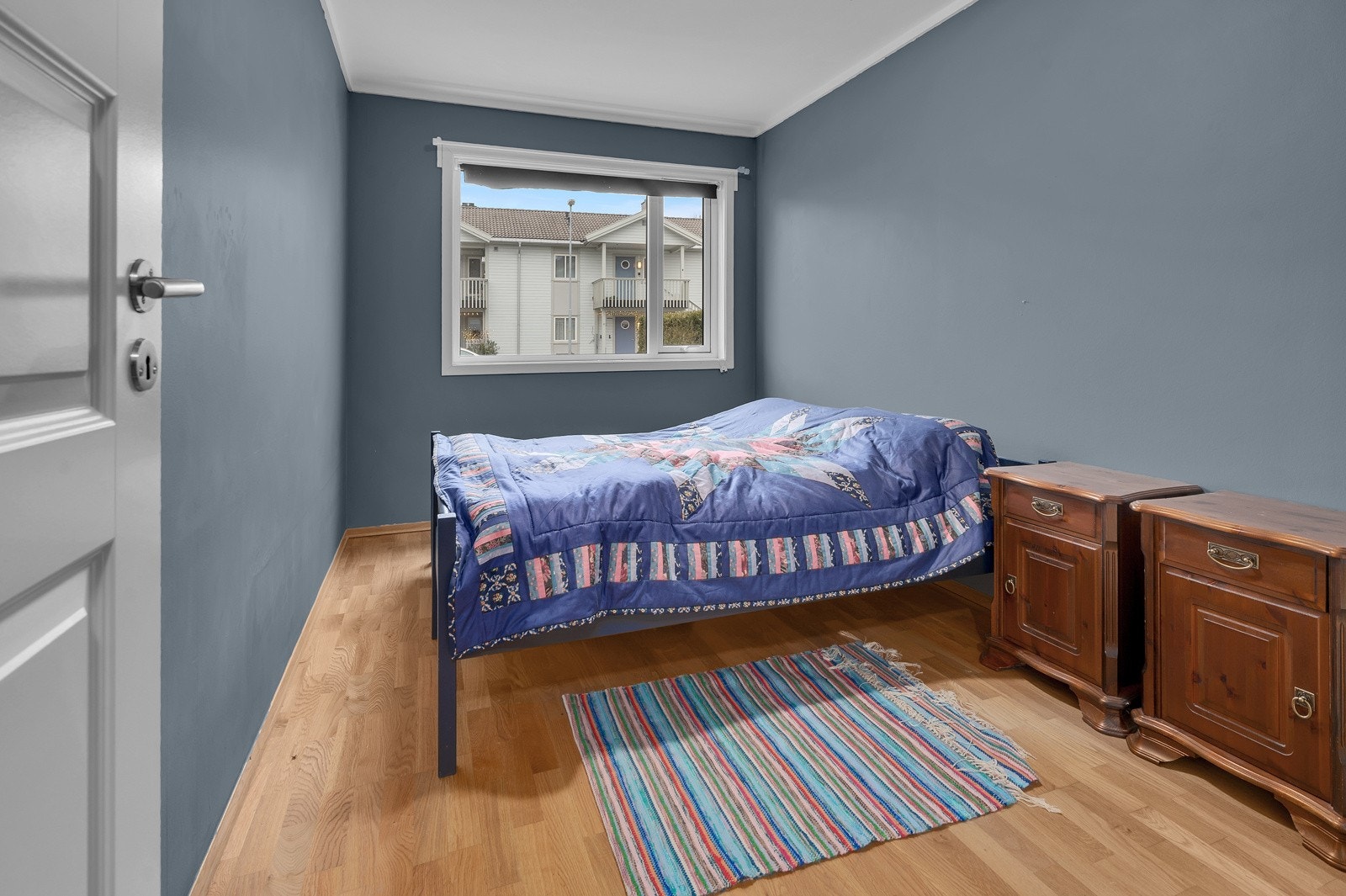 Romslig soverom som er malt i en behagelig blåtone, her er det plass til både seng og garderobeløsning Galleribilde