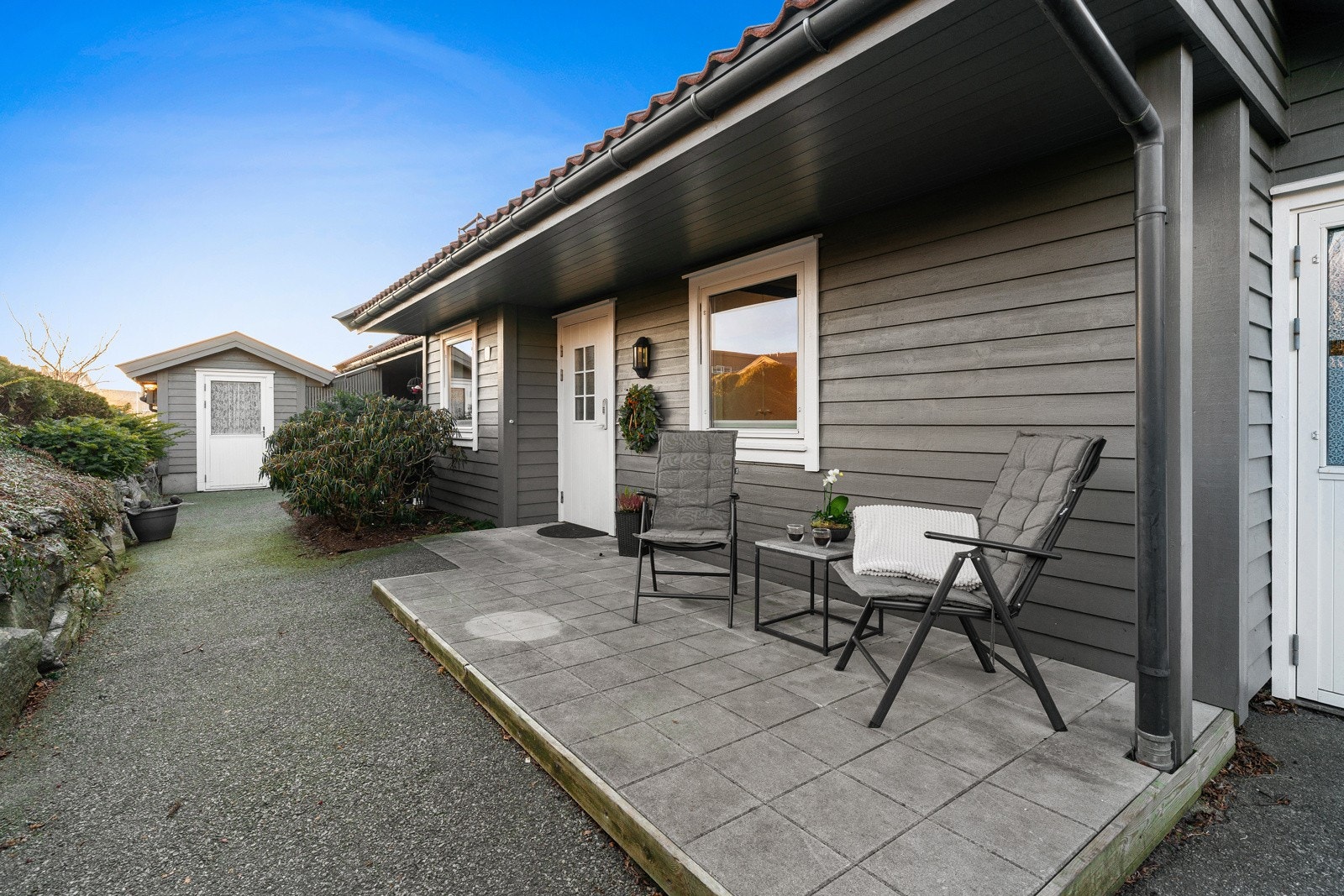 Boligens inngangsparti har plass til et kafésett hvor en kan nyte morgensolen og en kopp kaffe. Galleribilde