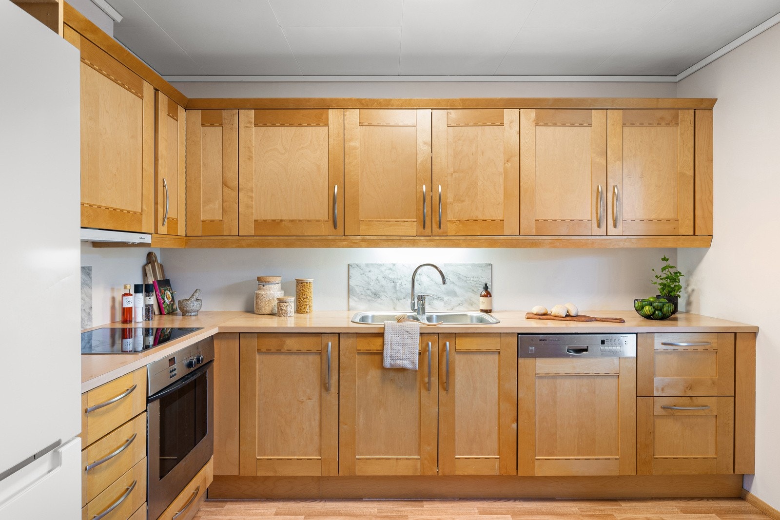 Kjøkkeninnredning med profilerte fronter og benkeplate i laminat. Galleribilde