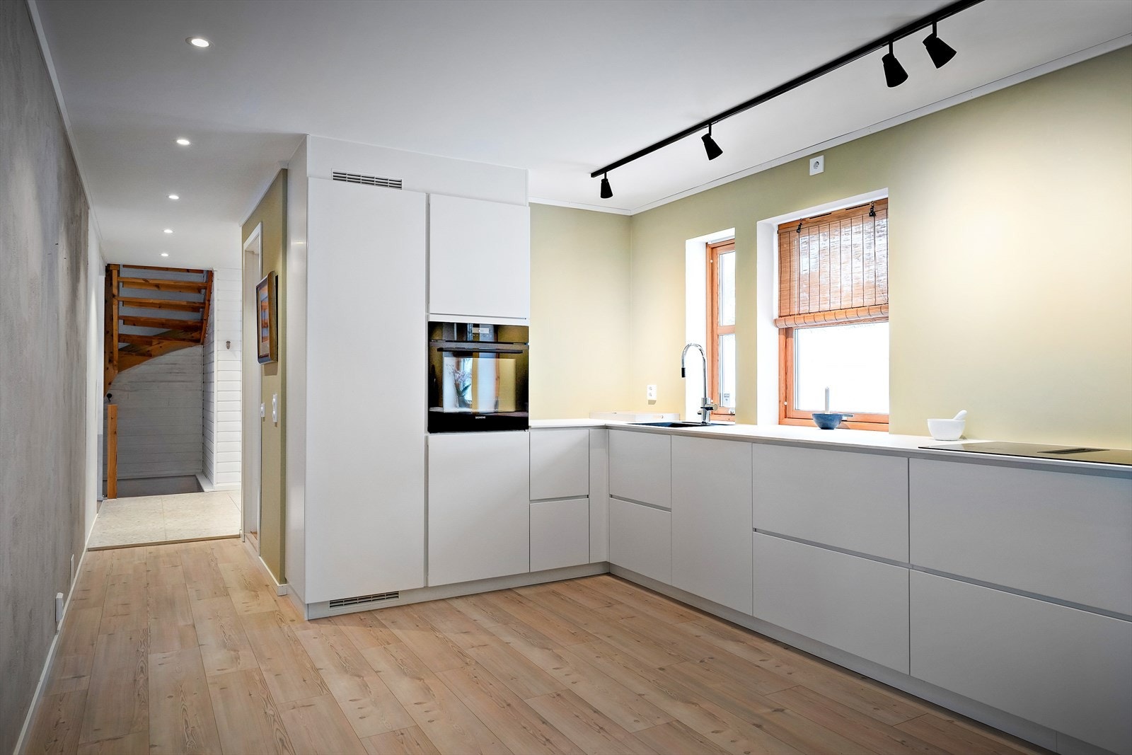 Kjøkkeninnredning fra 2023 med slette fronter og laminat benkeplate gir et moderne preg. Galleribilde