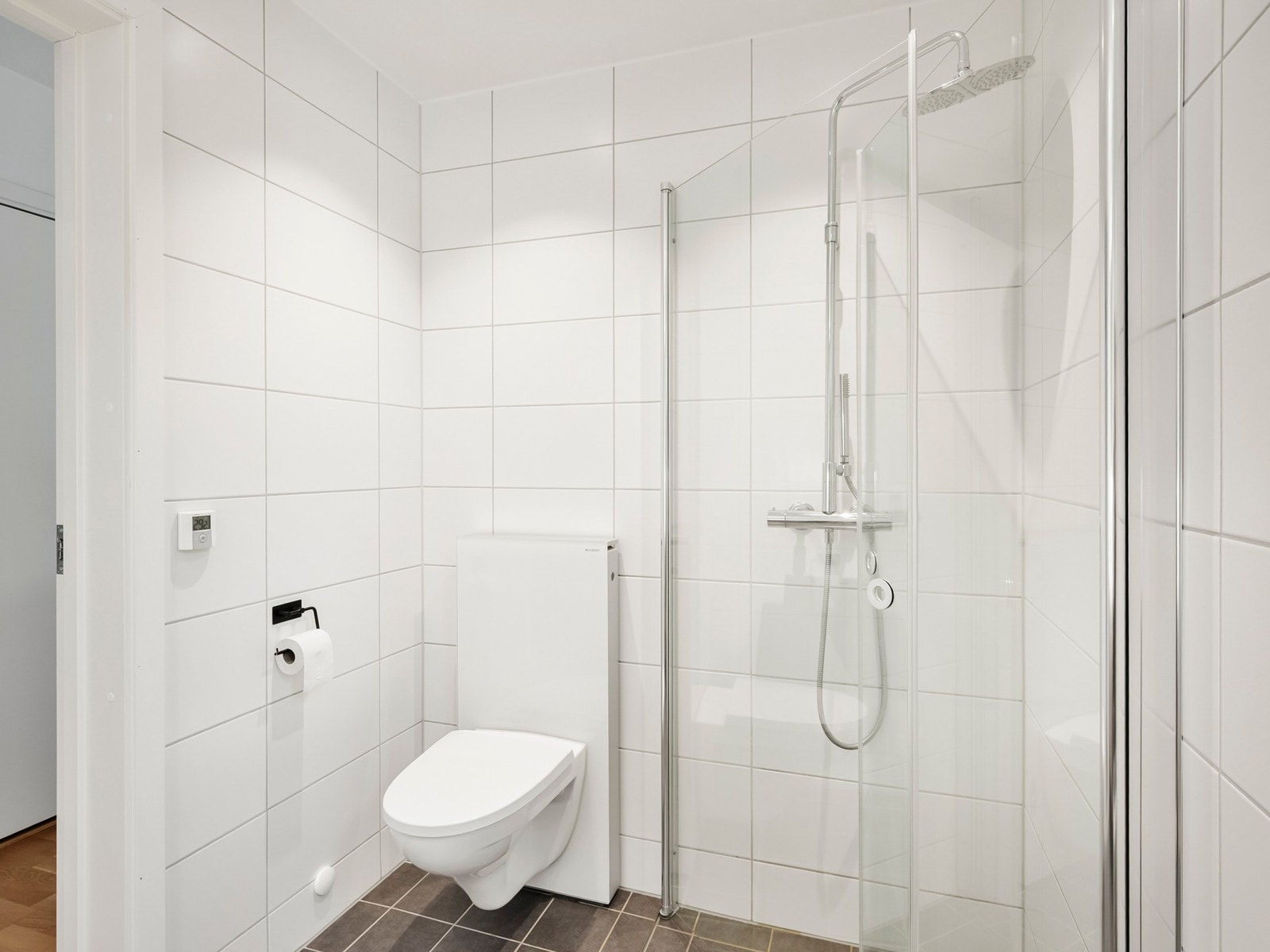 Innredningen bestående av servantinnredning med dobbeltskuff, vegghengt toalett og fossefallsdusj. Galleribilde