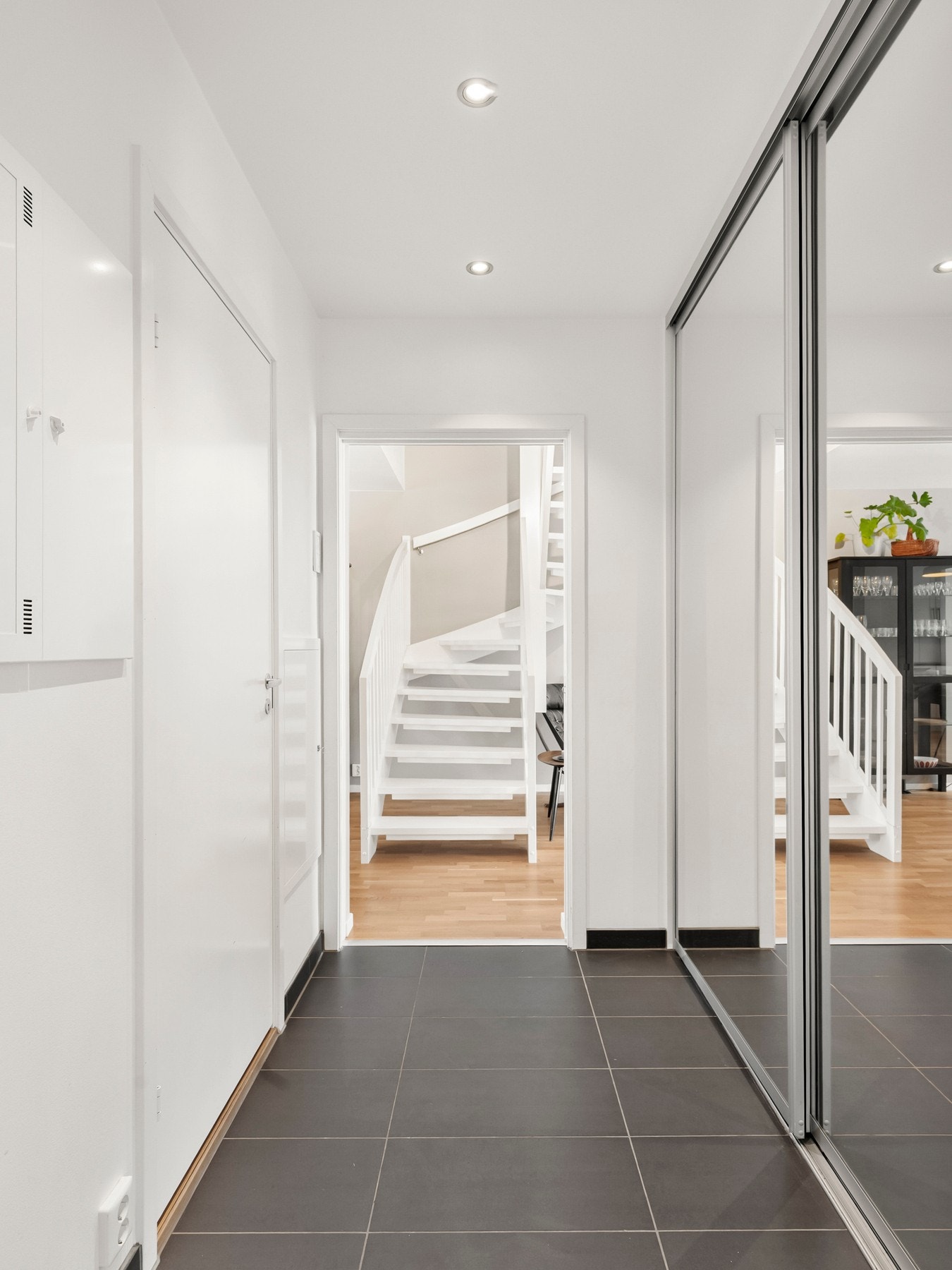 Innbydende entré med flislagt gulv og en romslig skyvedørsgarderobe med speilfronter. Galleribilde