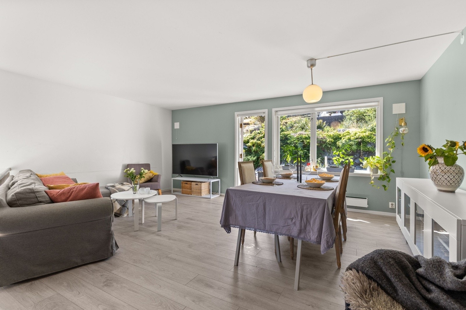 Romslig oppholdsrom med åpen løsning mot spiseplassen, som har flott utsikt mot grøntområde - et naturlig samlingspunkt for familie og venner. Galleribilde