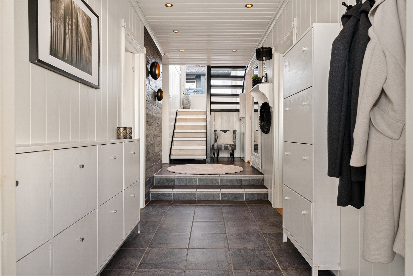 Inngangspartiet har flislagt gulv som er robust og tåler farting inn og ut med sko, grus og våte kjeledresser fra barnehagen. Galleribilde