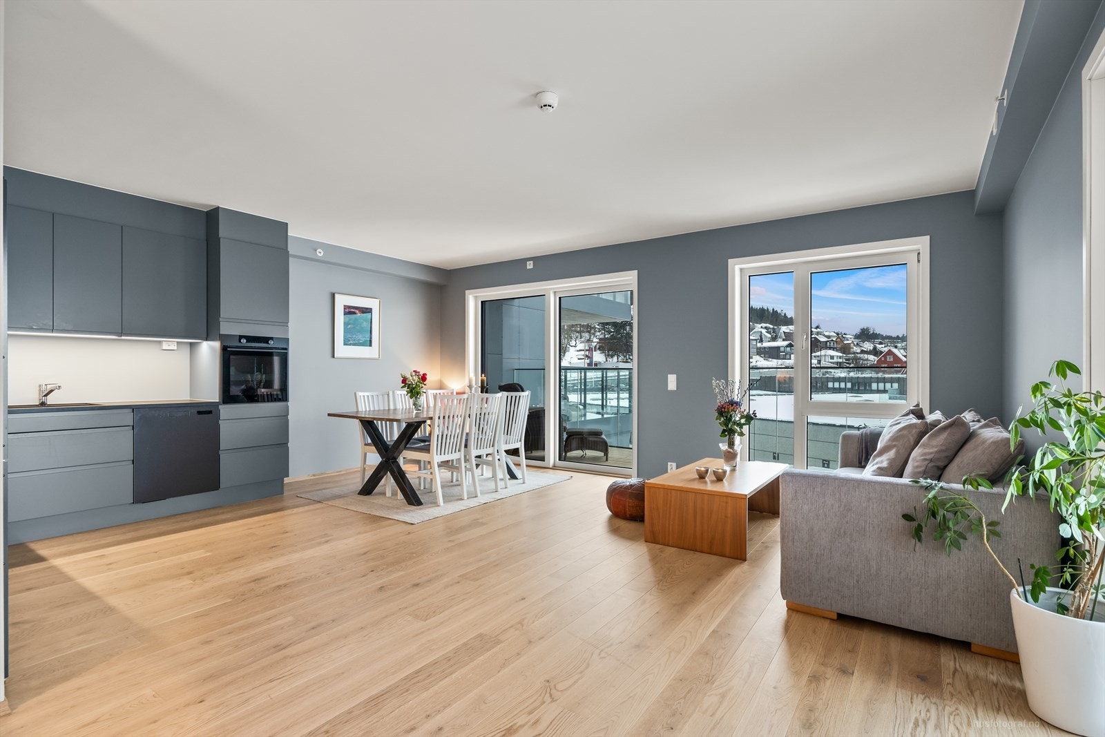 Åpen stue- og kjøkkenløsning med 1-stavs eikeparkett og moderne fargevalg. Galleribilde