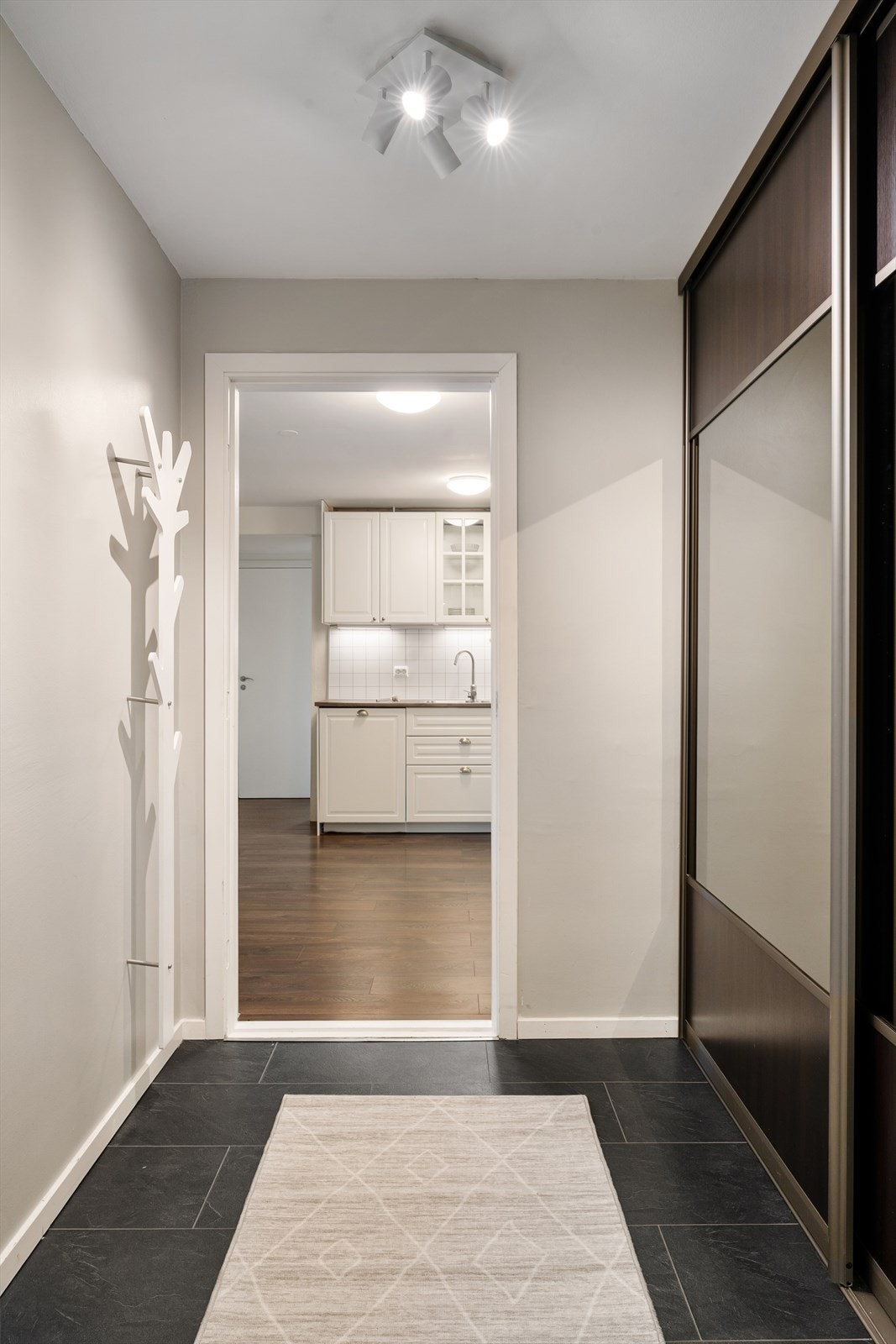 Innbydende entré med stor skyvedørsgarderobe Galleribilde