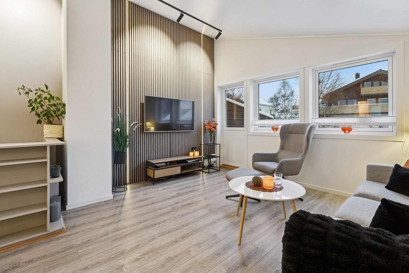 Spennende stue med skråtak. Legg merke til spileveggen med ledstriper og opplyst av moderne spottskinne. Døren tar deg ut til ... Galleribilde