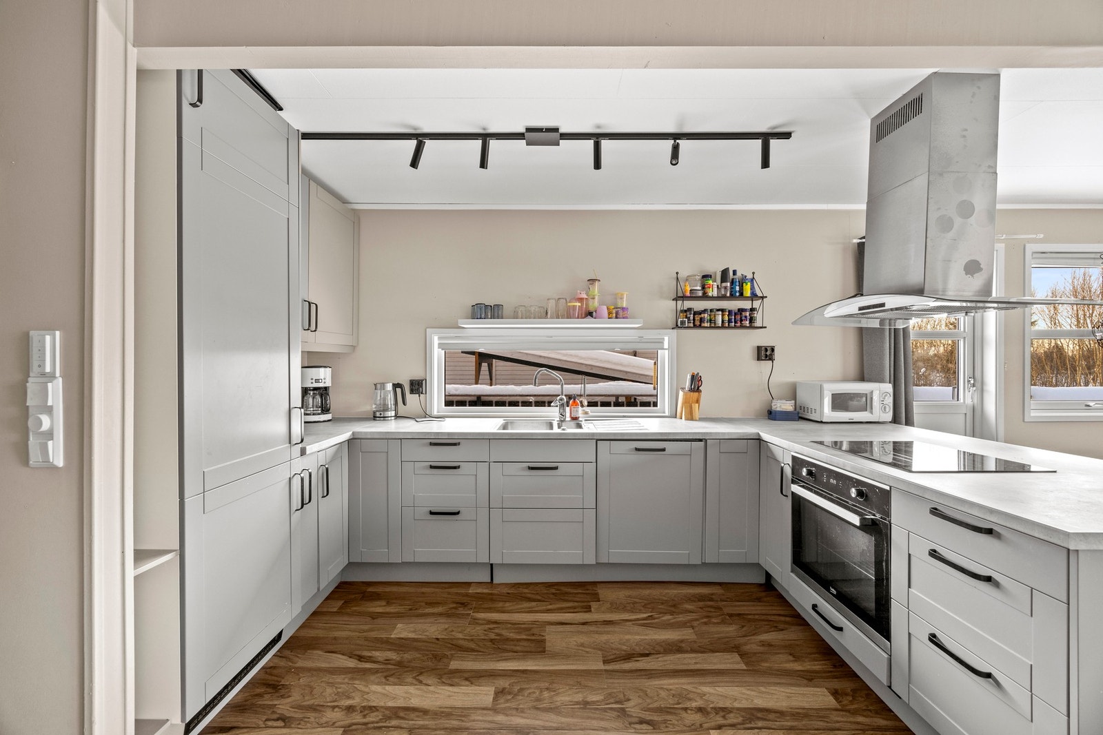 Pen og moderne kjøkkeninnredning med integrerte hvitevarer. Kjøkkenet er 9 kvm. Galleribilde