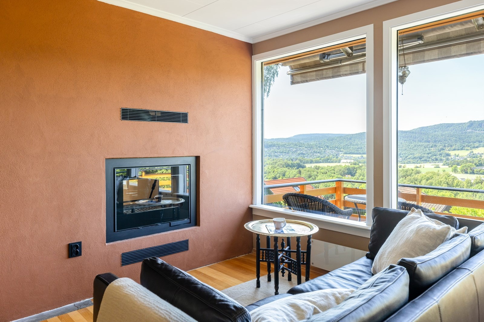 En moderne peis med glassdører på to sider fungerer som et elegant midtpunkt og en god varmekilde. Galleribilde