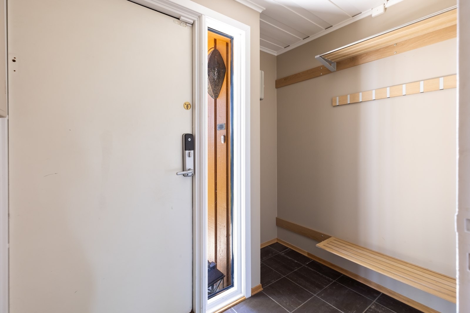 Boligens inngangsparti i underetasjen ønsker velkommen inn i et praktisk vindfang. Her er det god plass til å henge fra seg yttertøy og sette fra seg sko. Galleribilde