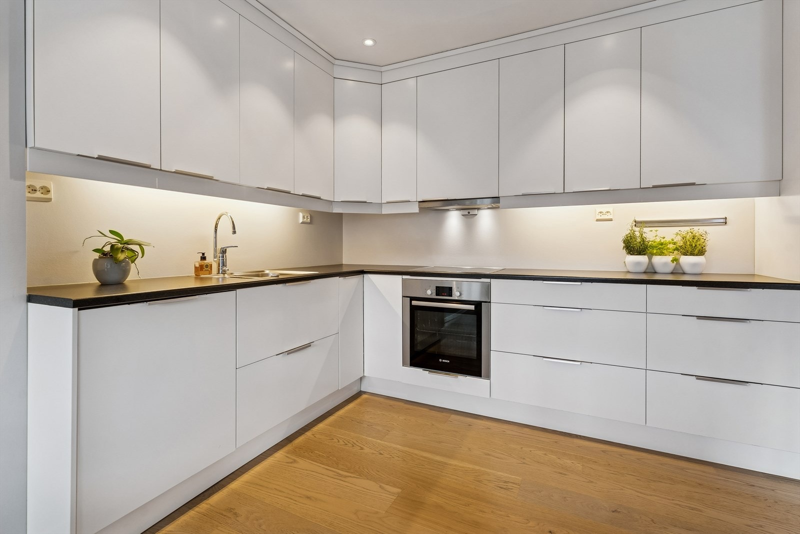 Lyst og lekkert kjøkken med integrerte hvitevarer Galleribilde