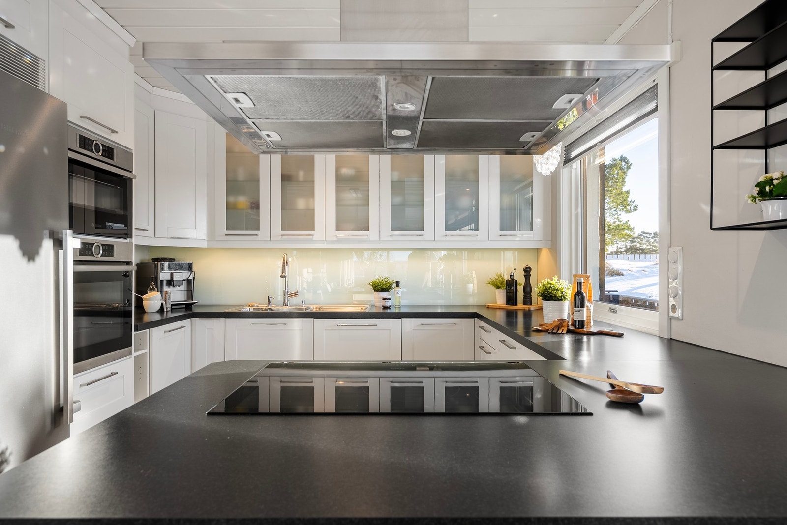 Moderne kjøkken med integrerte hvitevarer og god skapplass. Det er skuffer i sokkelen på innredningen. Galleribilde