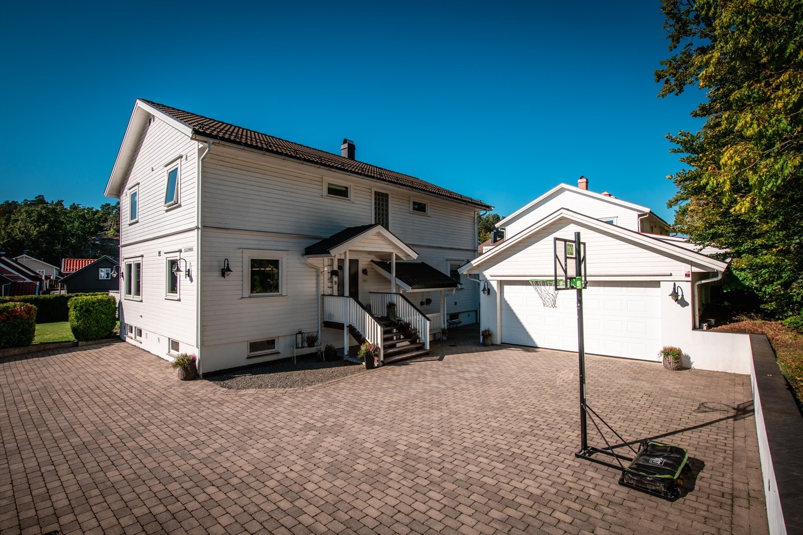 Gårdsplassen rommer et basketball-lag . Dobbel garasje med opplegg for elbil-lader. Galleribilde