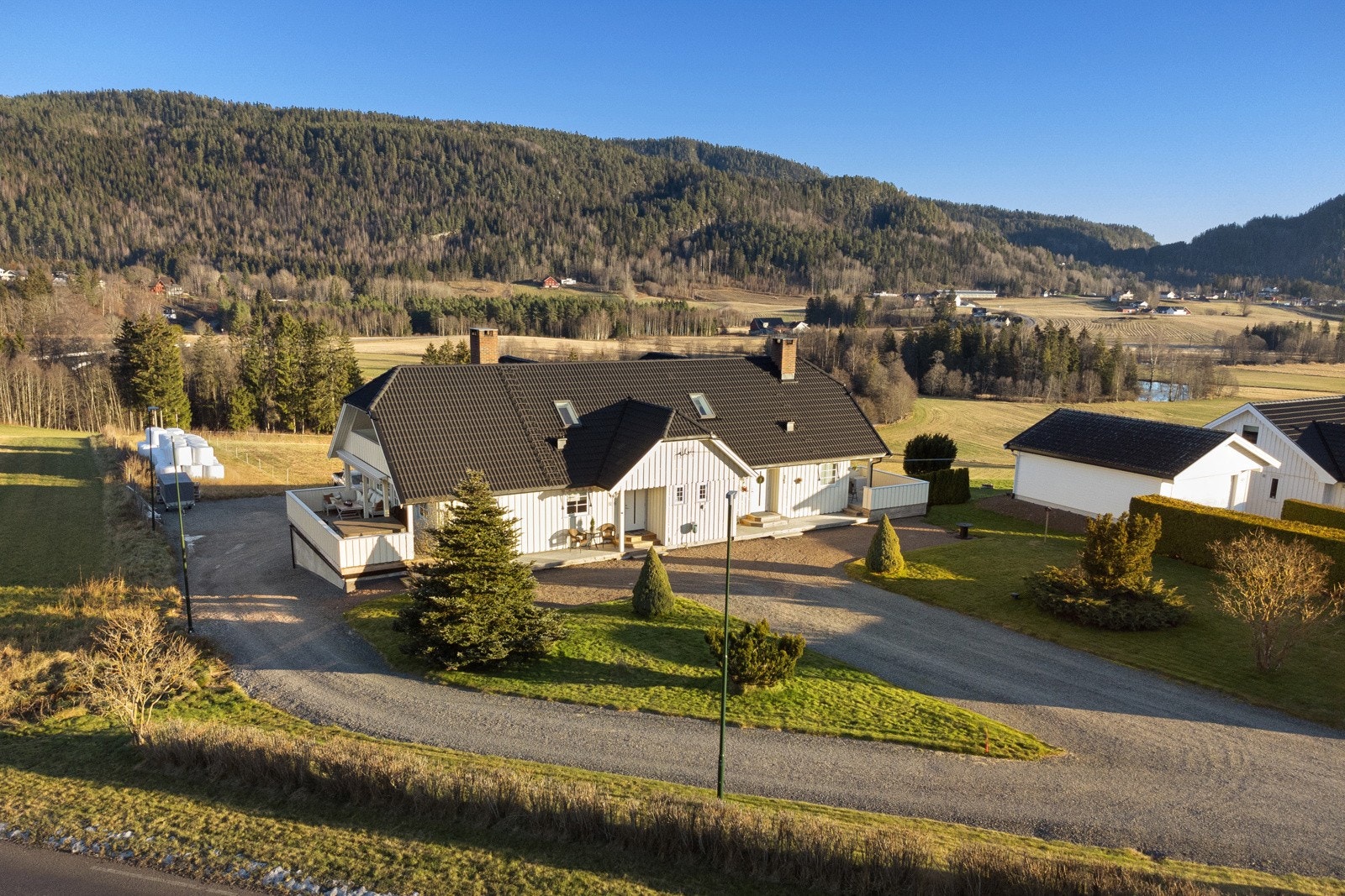Oppkjørsel og gårdsplass, belagt med elvegrus og rammer eiendommen inn på ryddig vis Galleribilde