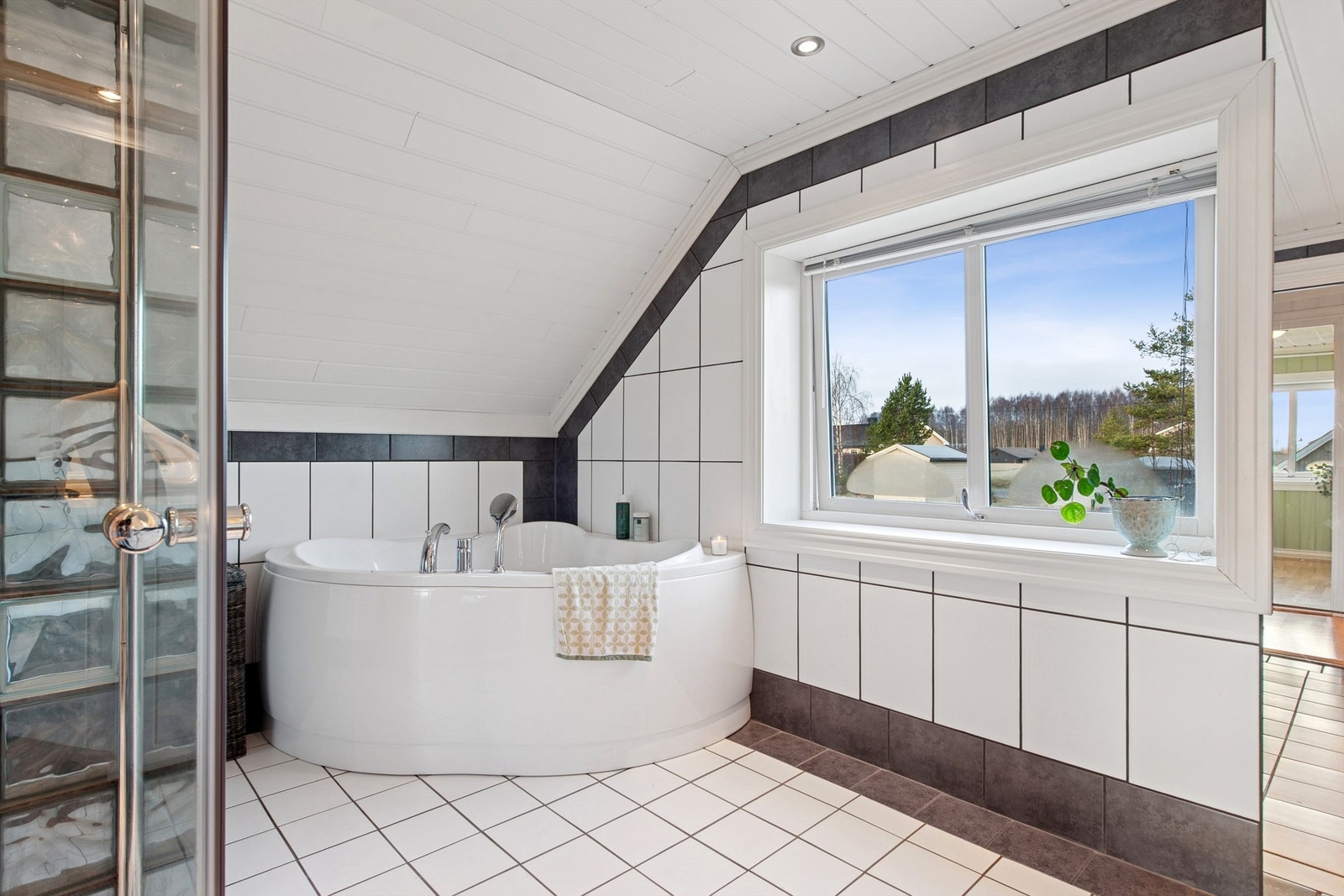 Baderommet i loftsetasjen er flislagt med gulvvarme og har både badekar og dusjnisje med dører. Galleribilde