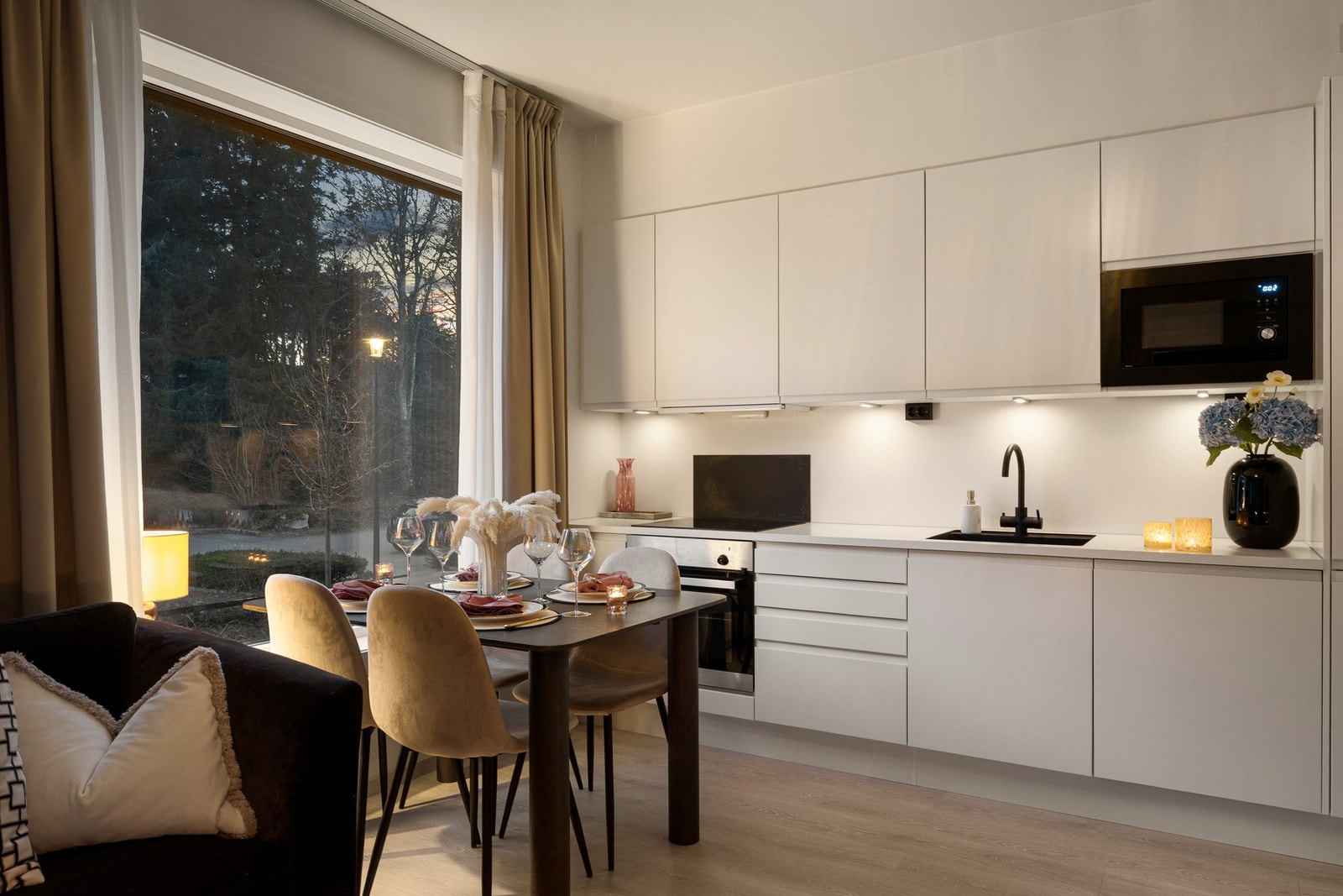 Frontene er i en hvit, grepsfri modell, kombinert med hvit benkeplate med nedfelt servant i sort. Galleribilde