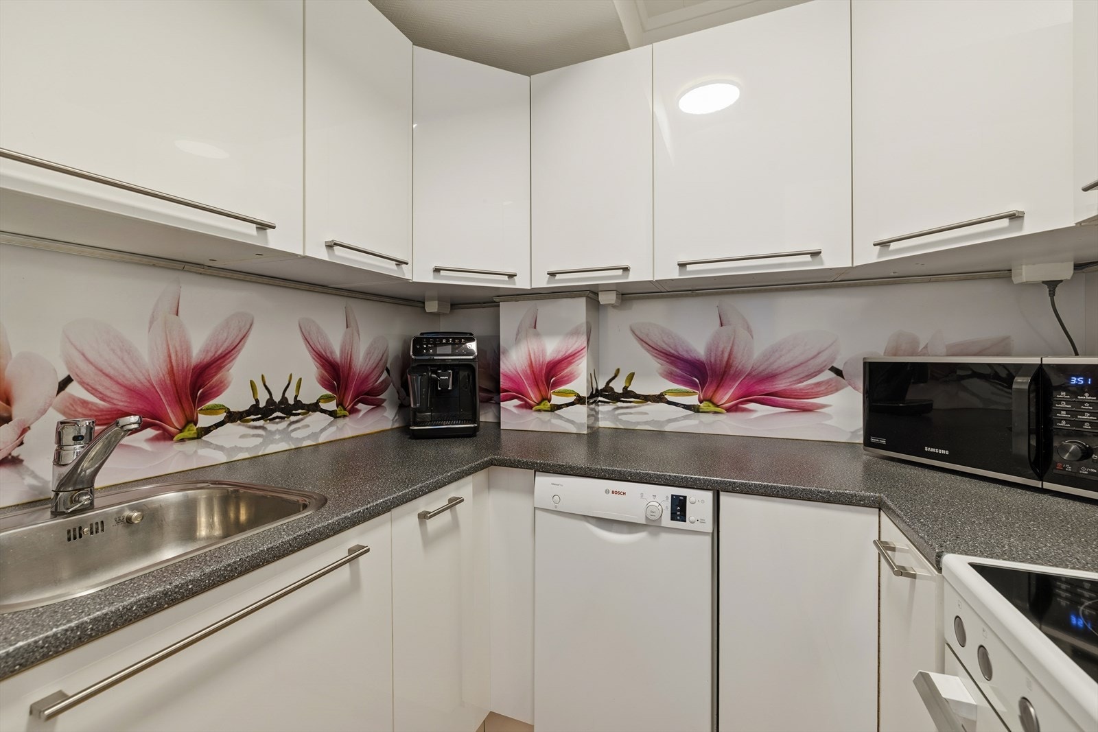 Kjøkkenet har en innredning med glatte fronter som er av nyere dato enn selve skrogene og laminat benkeplate med oppvaskkum. Galleribilde