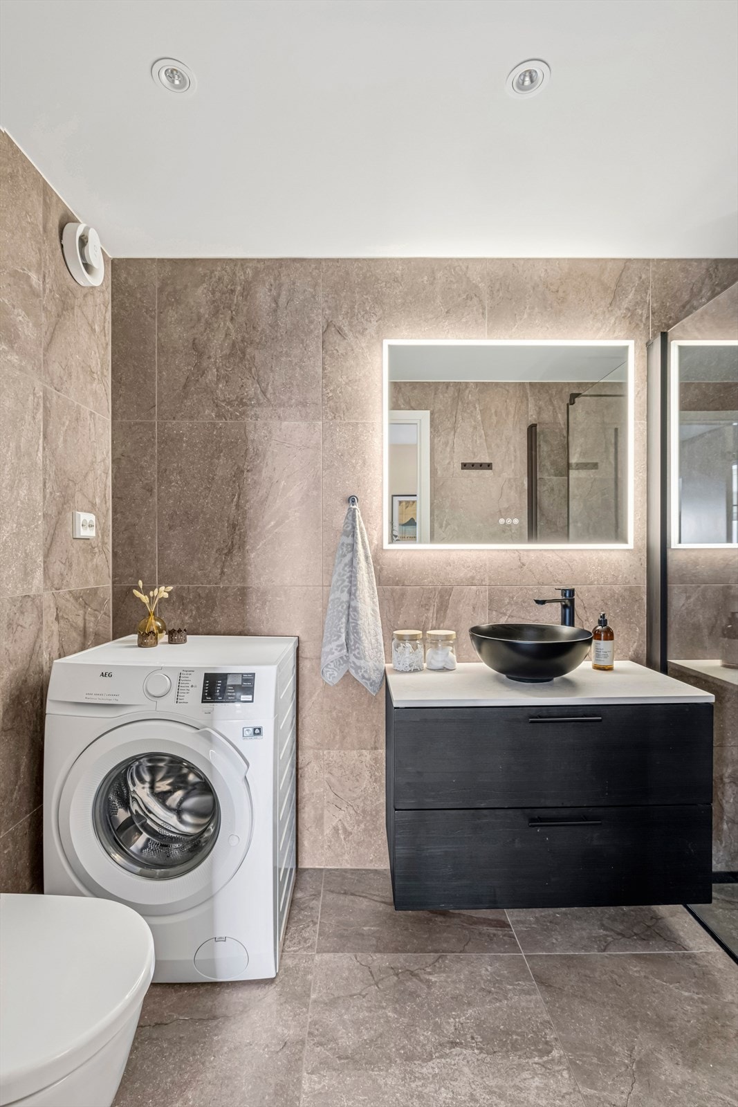 Utstyrt med stilrent, vegghengt wc samt opplegg for vaskemaskin. Galleribilde