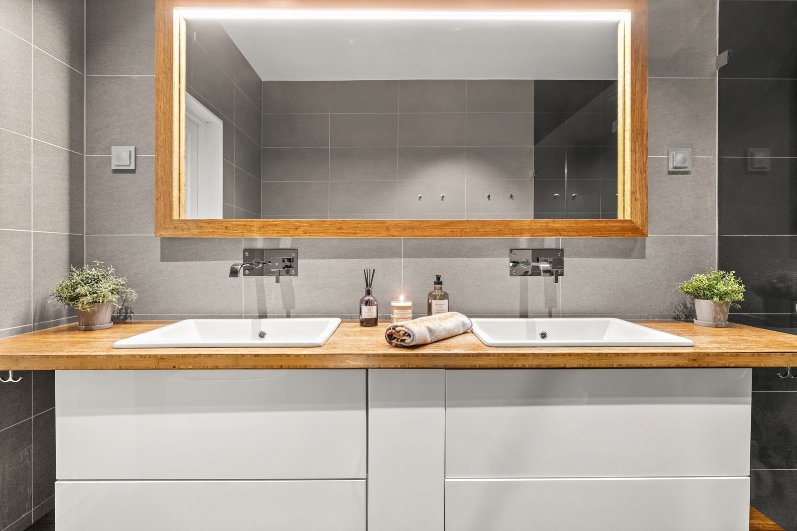 Badet har dobbel servantløsning, speil med belysning og oppbevaringsløsning. Galleribilde