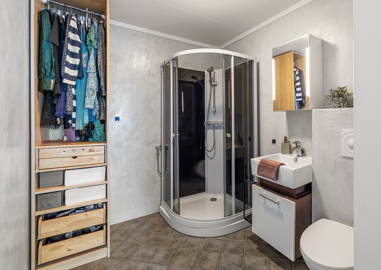 Fra soverommet er det inngang til et bad. Badet har fliser på gulv og microsement på vegger. Innredningen består av et underskap/overskap, servant, speil, stikk og ett dusjkabinett. I tillegg er det tilkoblet et vannklosett. Rommet har mekanisk avtrekk. Galleribilde