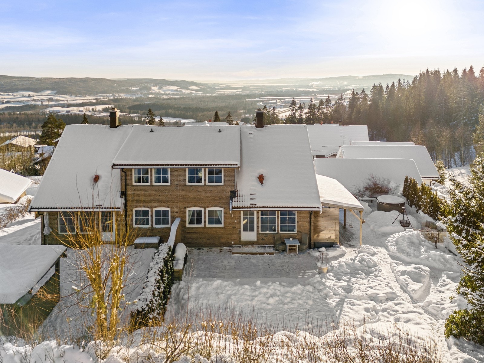 Boligen ligger på en pent opparbeidet tomt med en frittstående dobbelgarasje, plen, frodig beplantning og flere flotte uteplasser, herunder en hjørneterrasse på 100 m² med fantastisk utsikt. Galleribilde