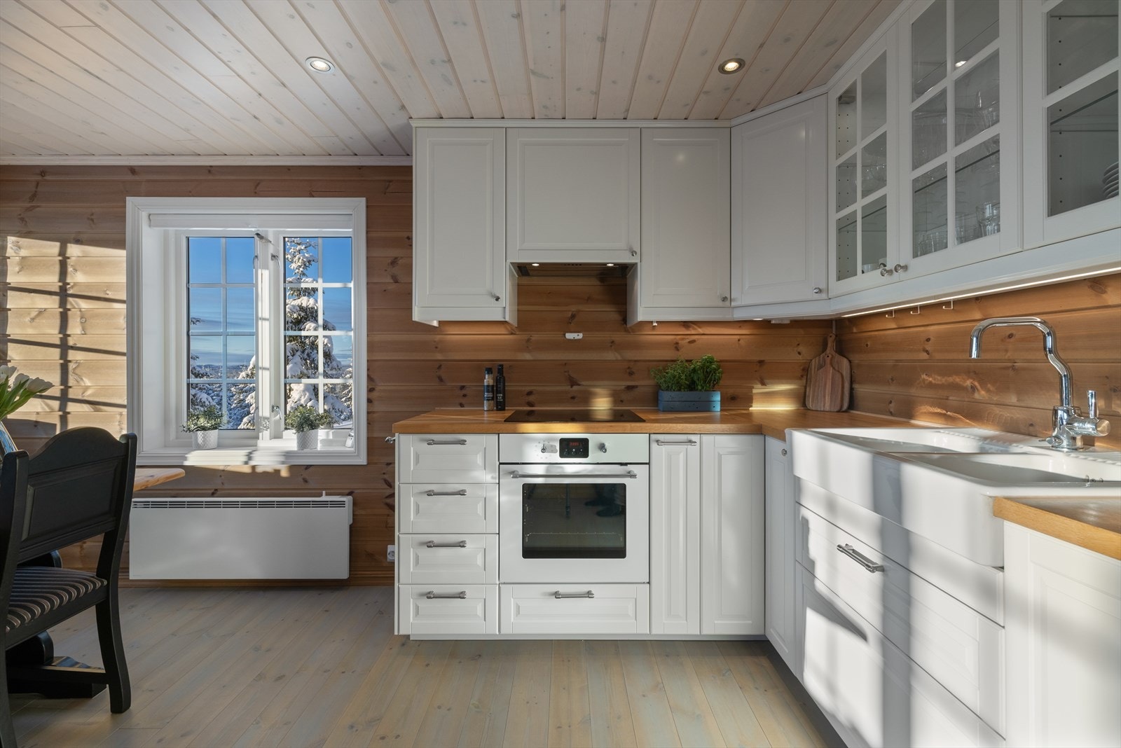 Kjøkkeninnredningen er pent utført med lyse, profilerte fronter og en benkeplate i heltre. Galleribilde