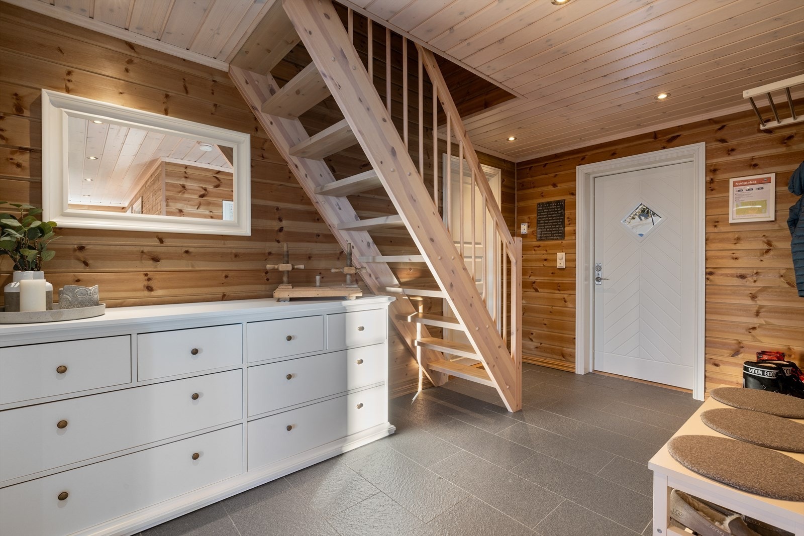 En romslig og fliselagt entré med elektriske varmekabler i gulvet. Galleribilde