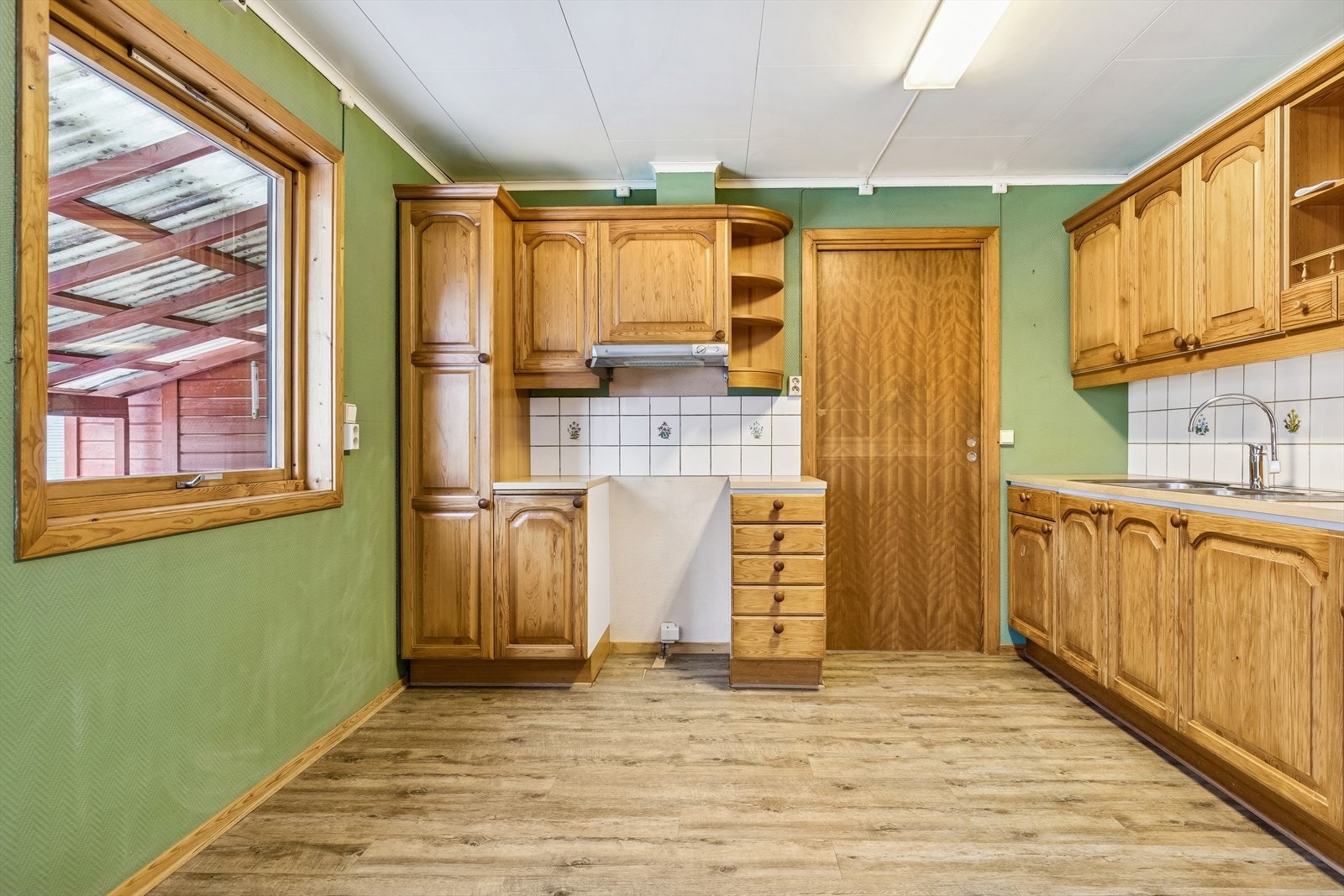 Kjøkkeninnredning fra byggeåret med fronter i heltre og laminat benkeplate. Galleribilde