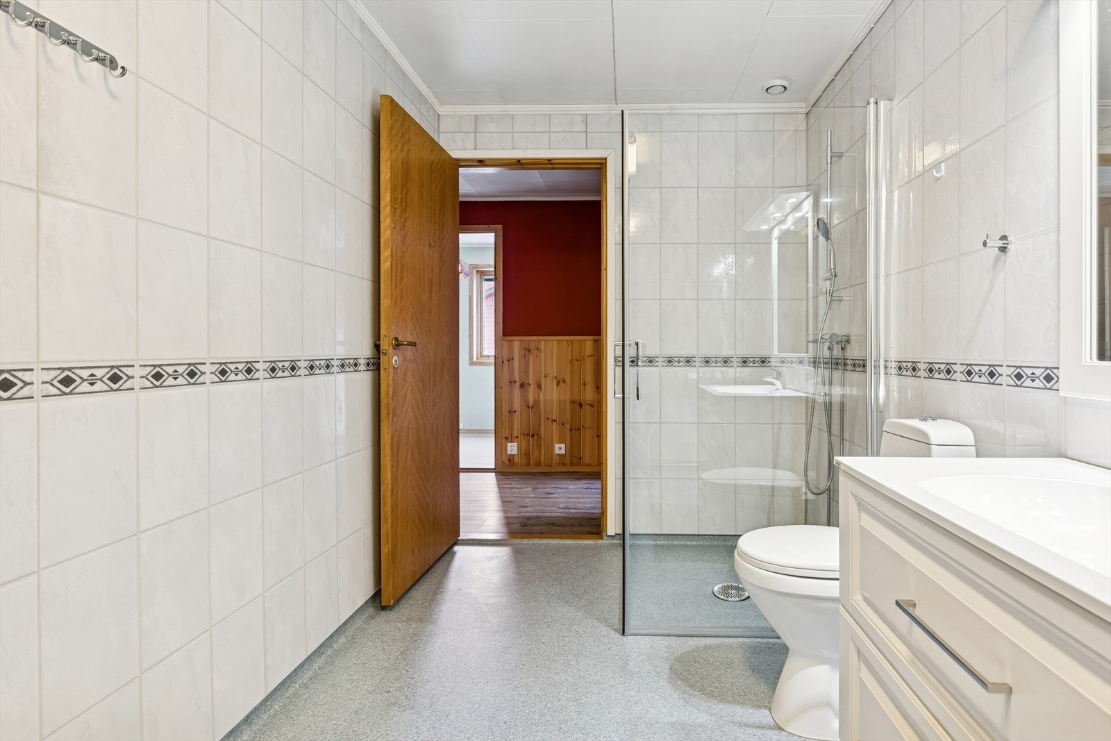 Dette er et romslig bad og vaskerom med våtromsplater på veggene og vinylbelegg på gulv. Galleribilde