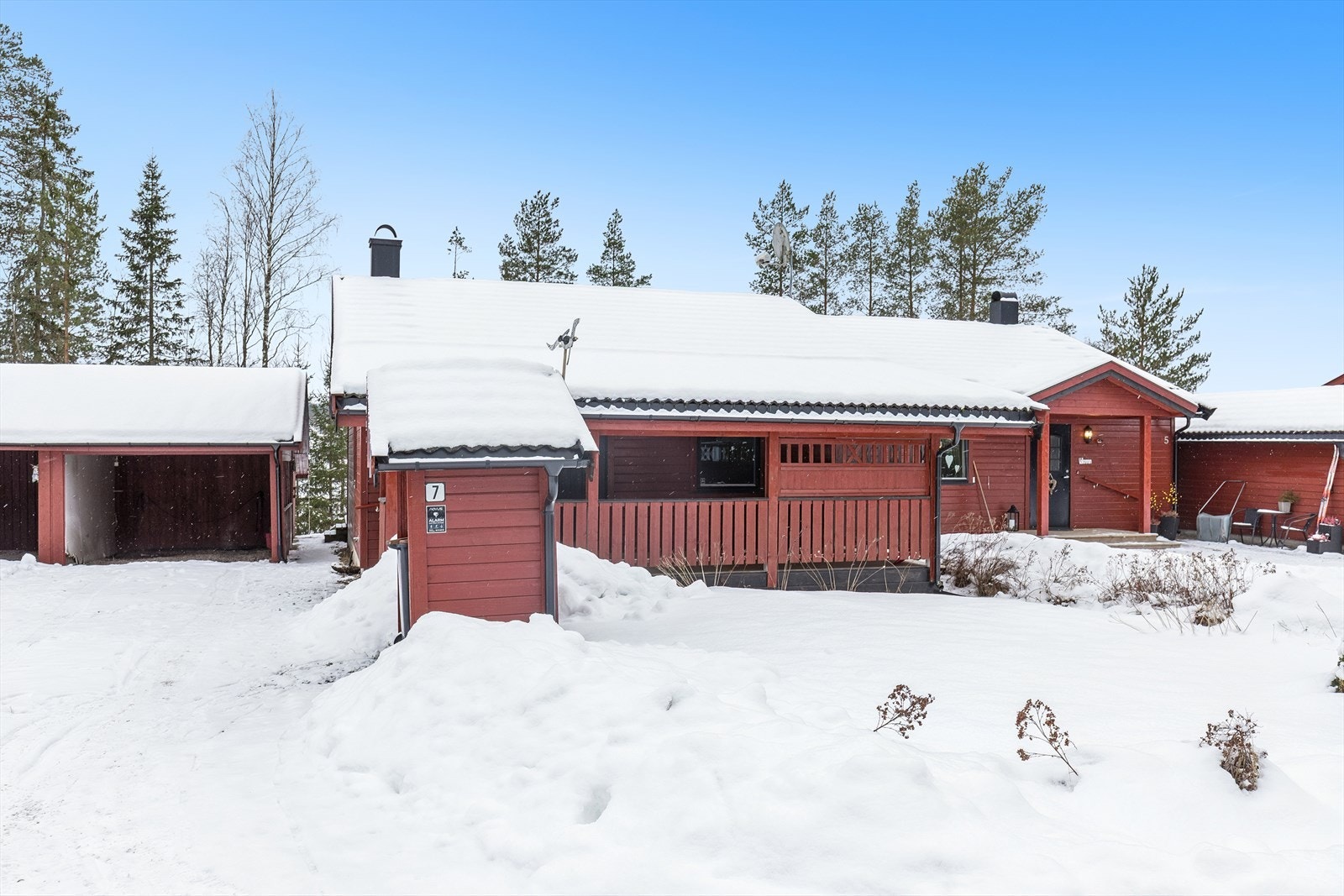 Carport like ved inngangsdøren, med to tilhørende boder i bakkant for ekstra lagringsplass. Galleribilde