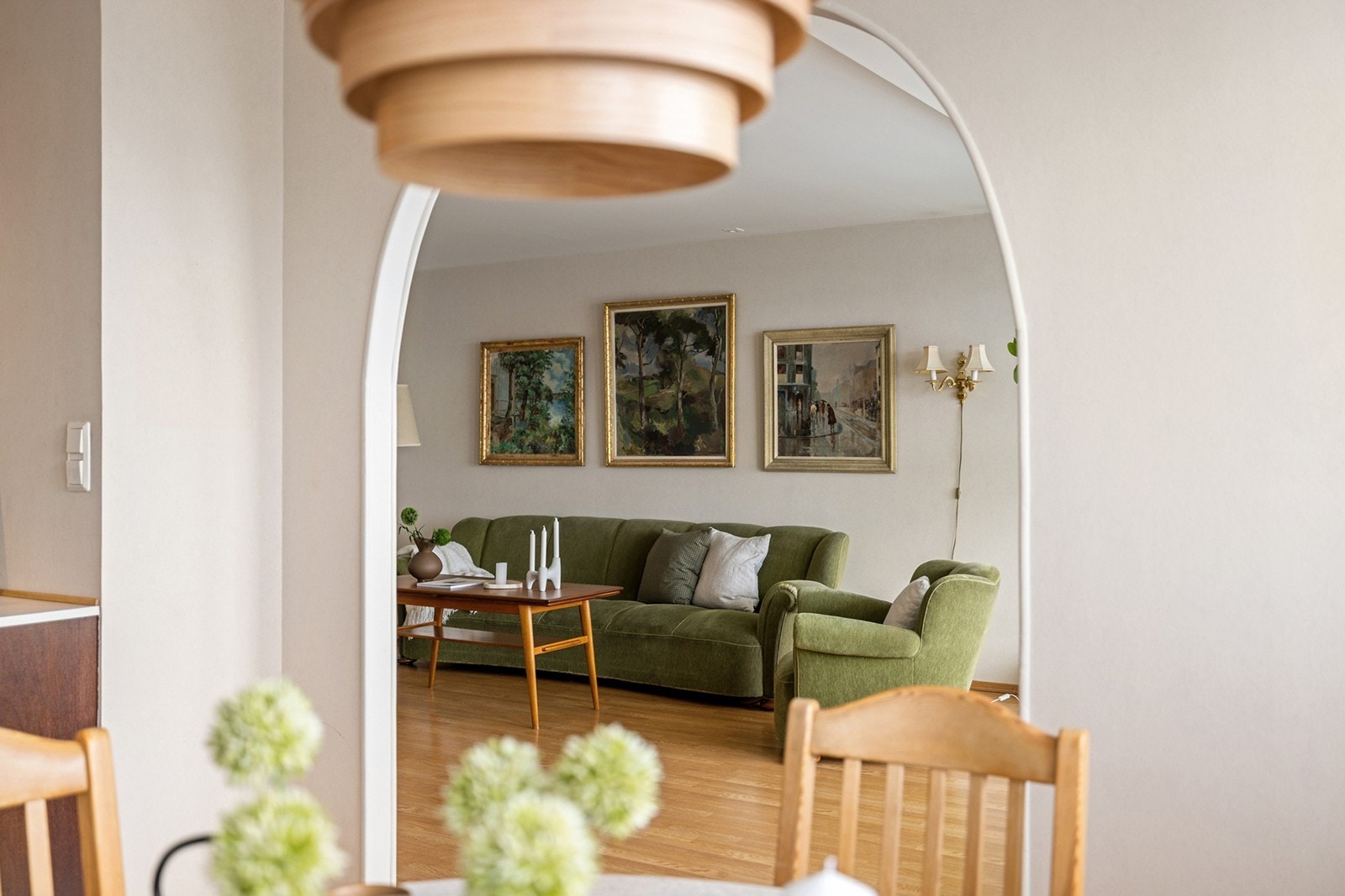 Fra kjøkkenets spiseplass er det en naturlig overgang til den romslige stuen gjennom en elegant buet åpning, som skaper en luftig og sammenhengende romfølelse. Galleribilde