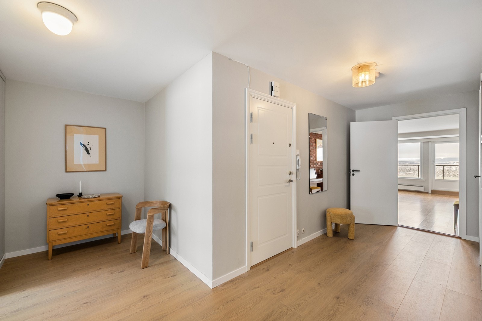 Lys og romslig oppusset gang/entré med laminatgulv, og malte slette vegger og himling. Her er det god plass til garderobeløsning og annet møblement. Galleribilde