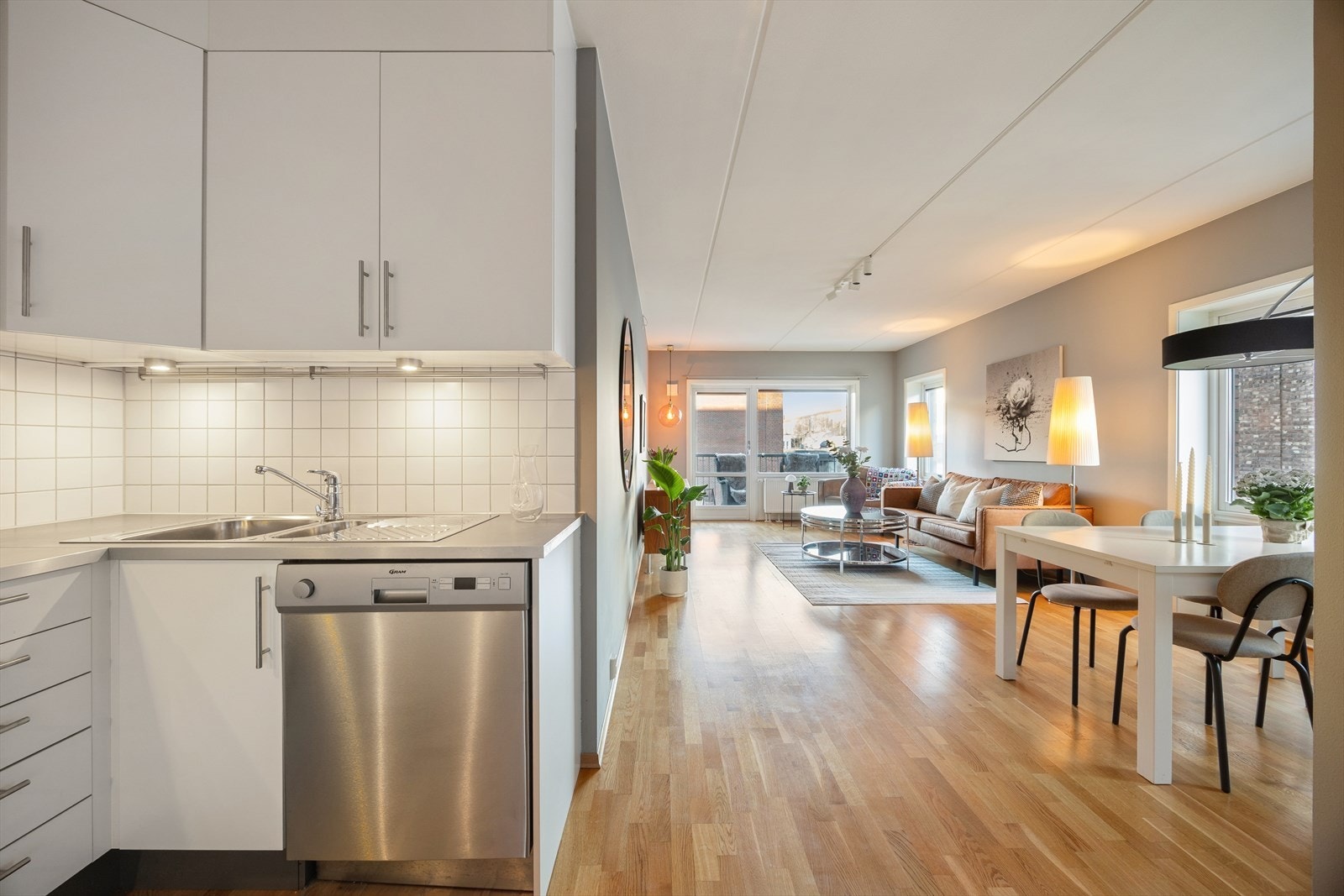 Den åpne løsningen mellom stue og kjøkken skaper en luftig og sosial atmosfære, ideelt for samvær. Galleribilde